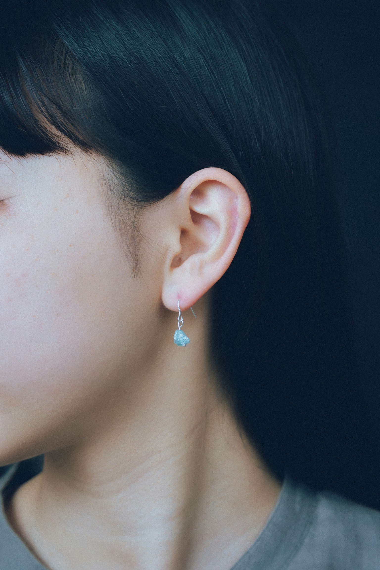 Gros plan sur une femme portant une boucle d'oreille bleue