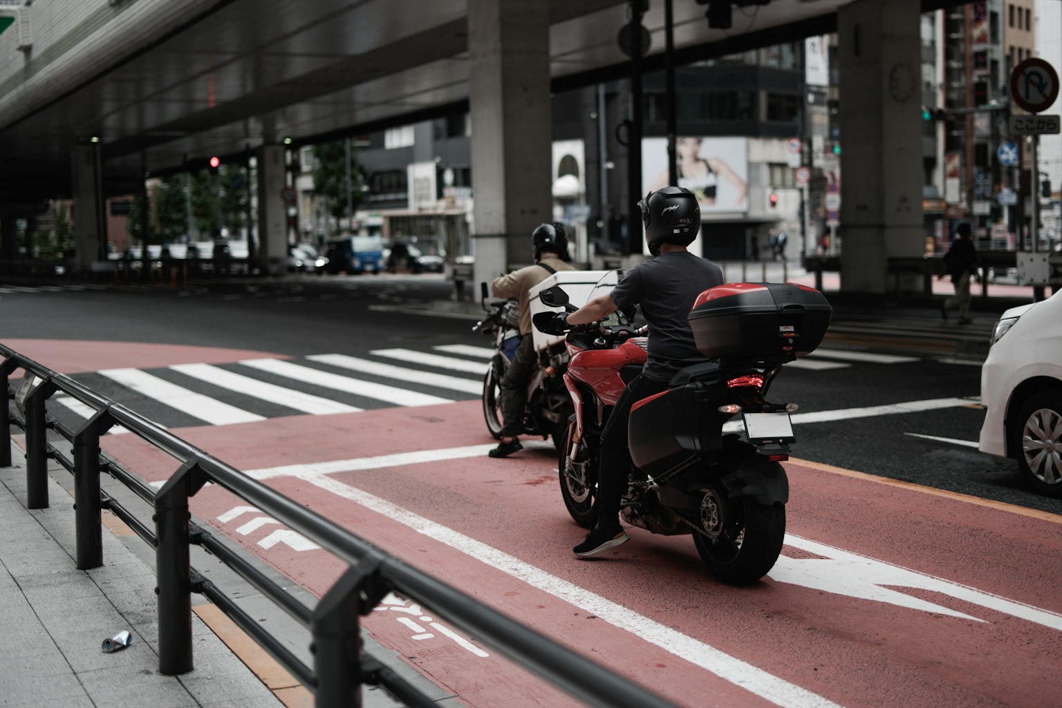 兩名騎手在城市環境中沿紅色車道行駛