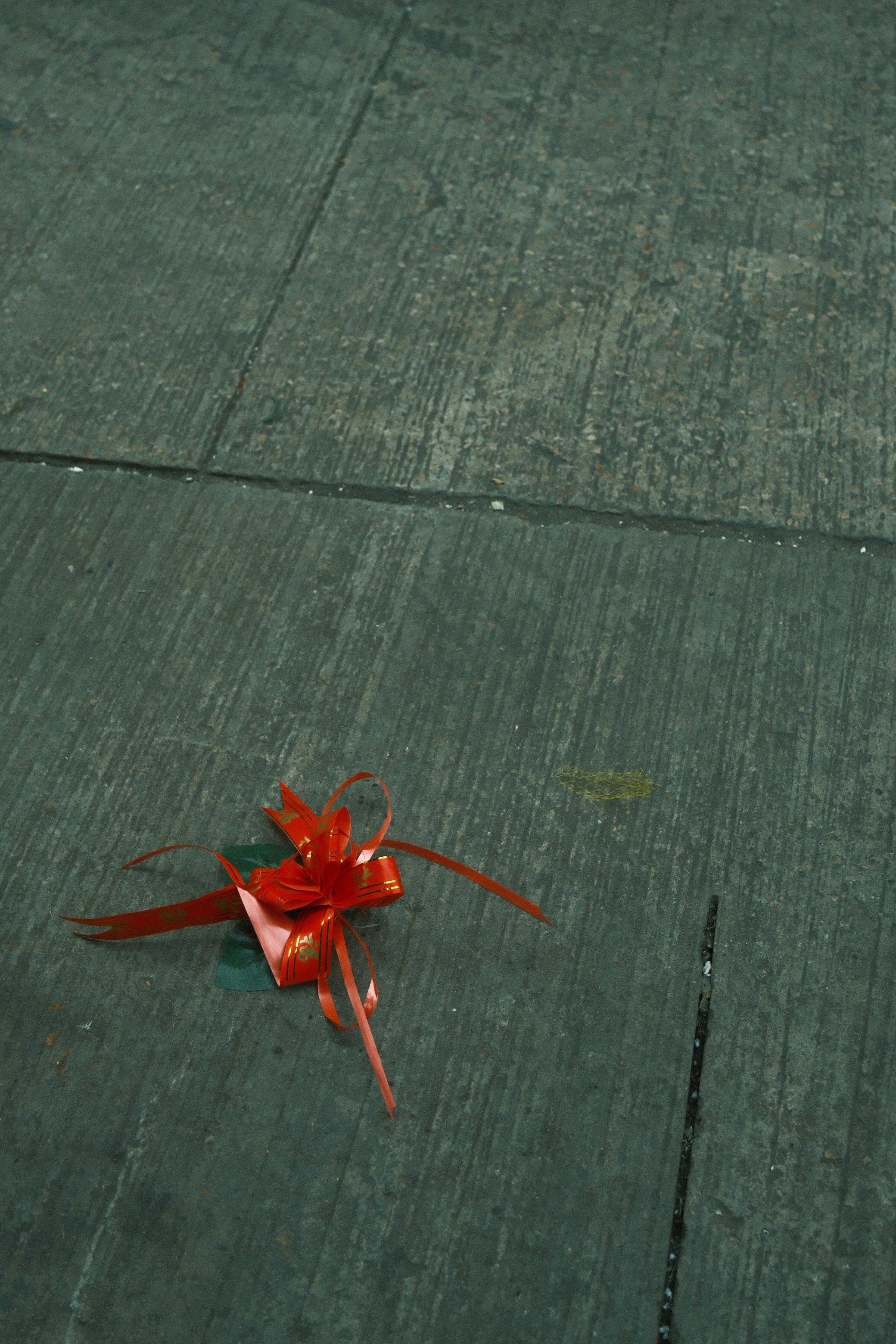 Un cadeau rouge avec ruban sur un sol en bois vert