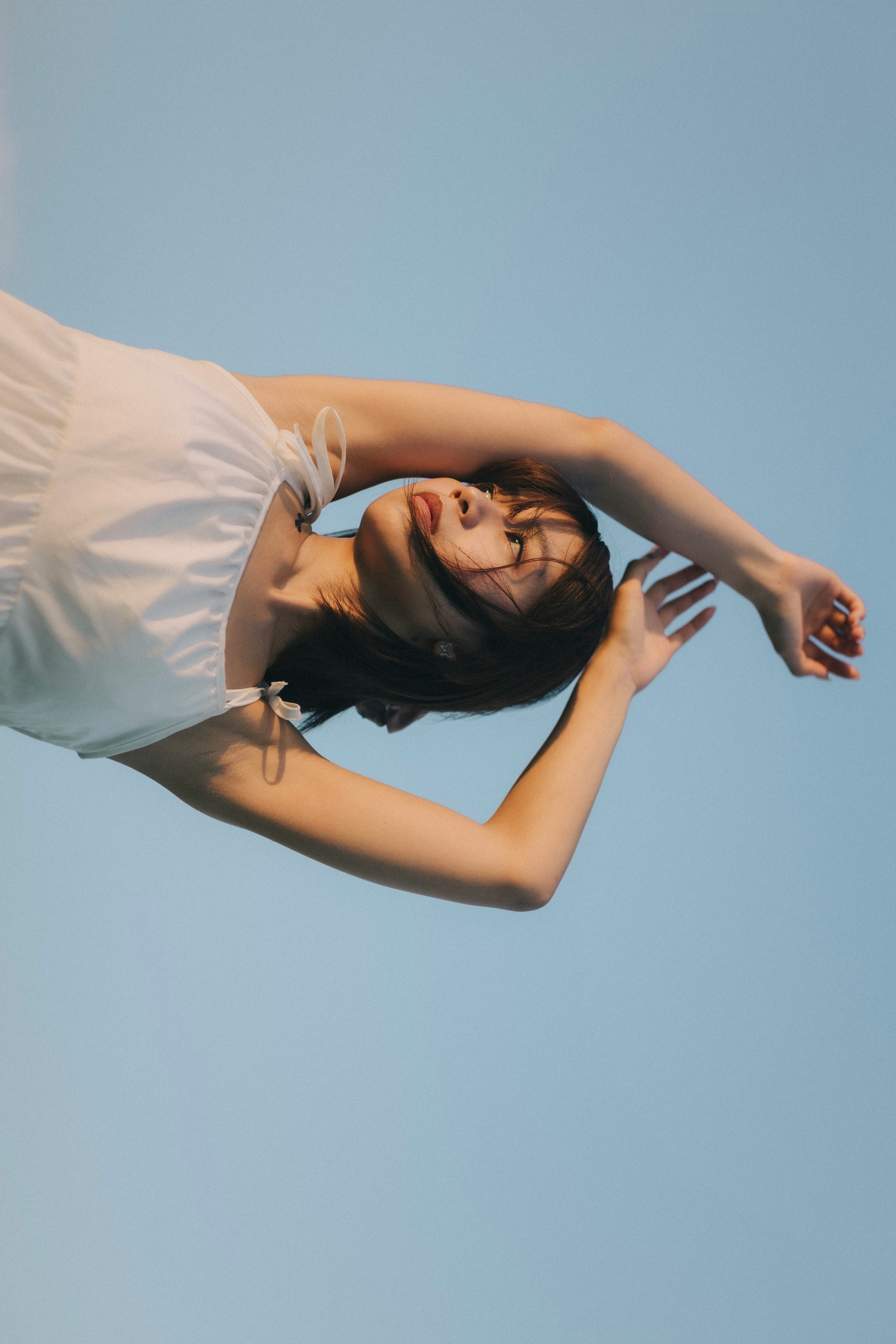 青空の下で横たわる女性のポートレート