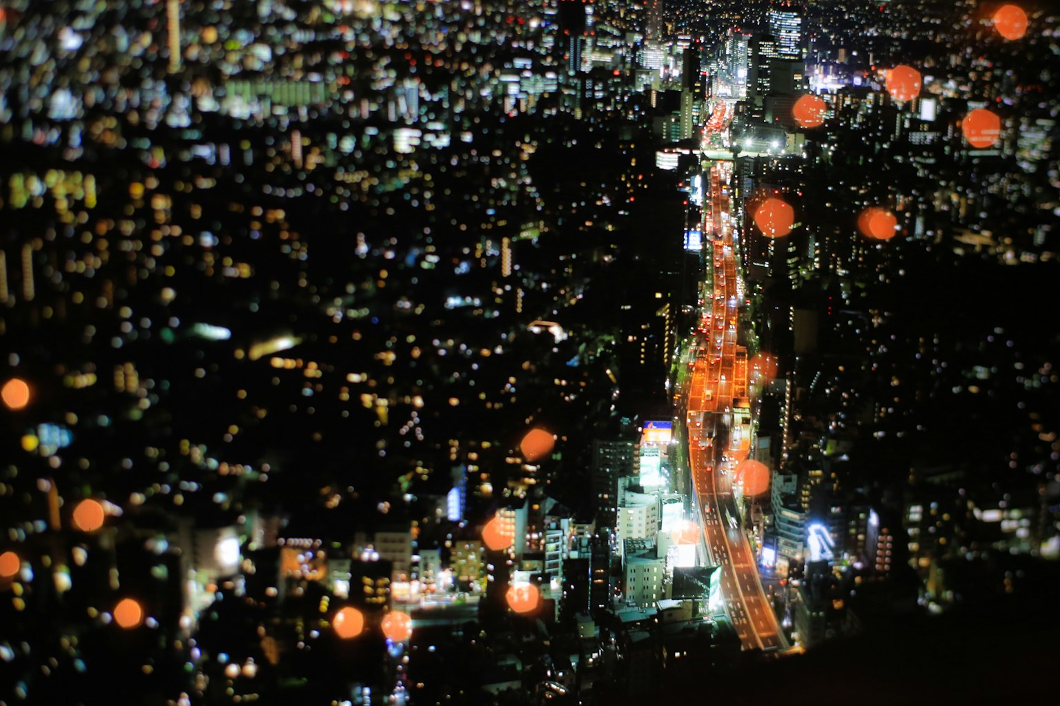 Pemandangan malam Tokyo dari udara dengan bangunan yang diterangi dan jalan utama