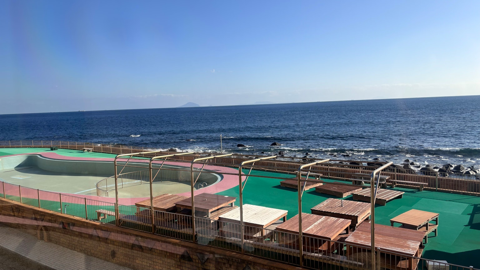 Vue sur la mer avec aire de jeux et tables en bois