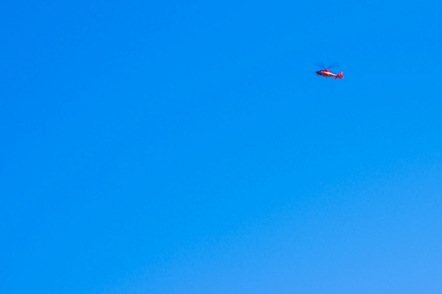 青空に浮かぶヘリの小さな機影