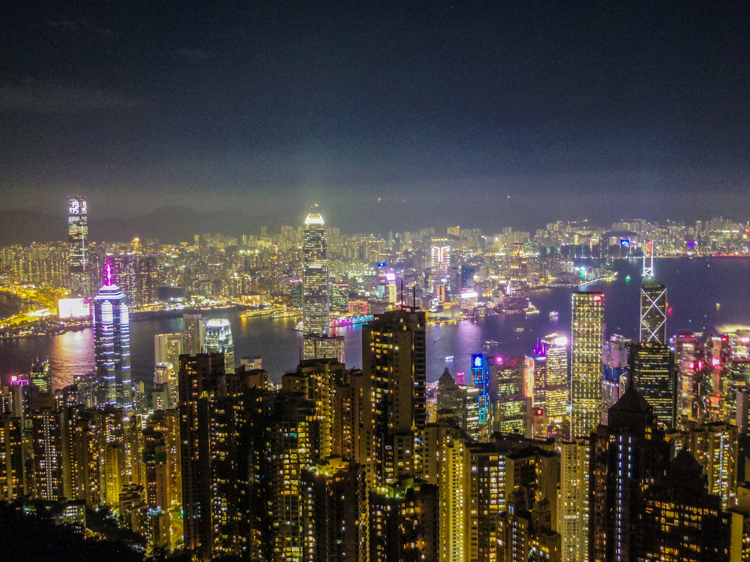 Vista notturna mozzafiato di Hong Kong con grattacieli illuminati e porto