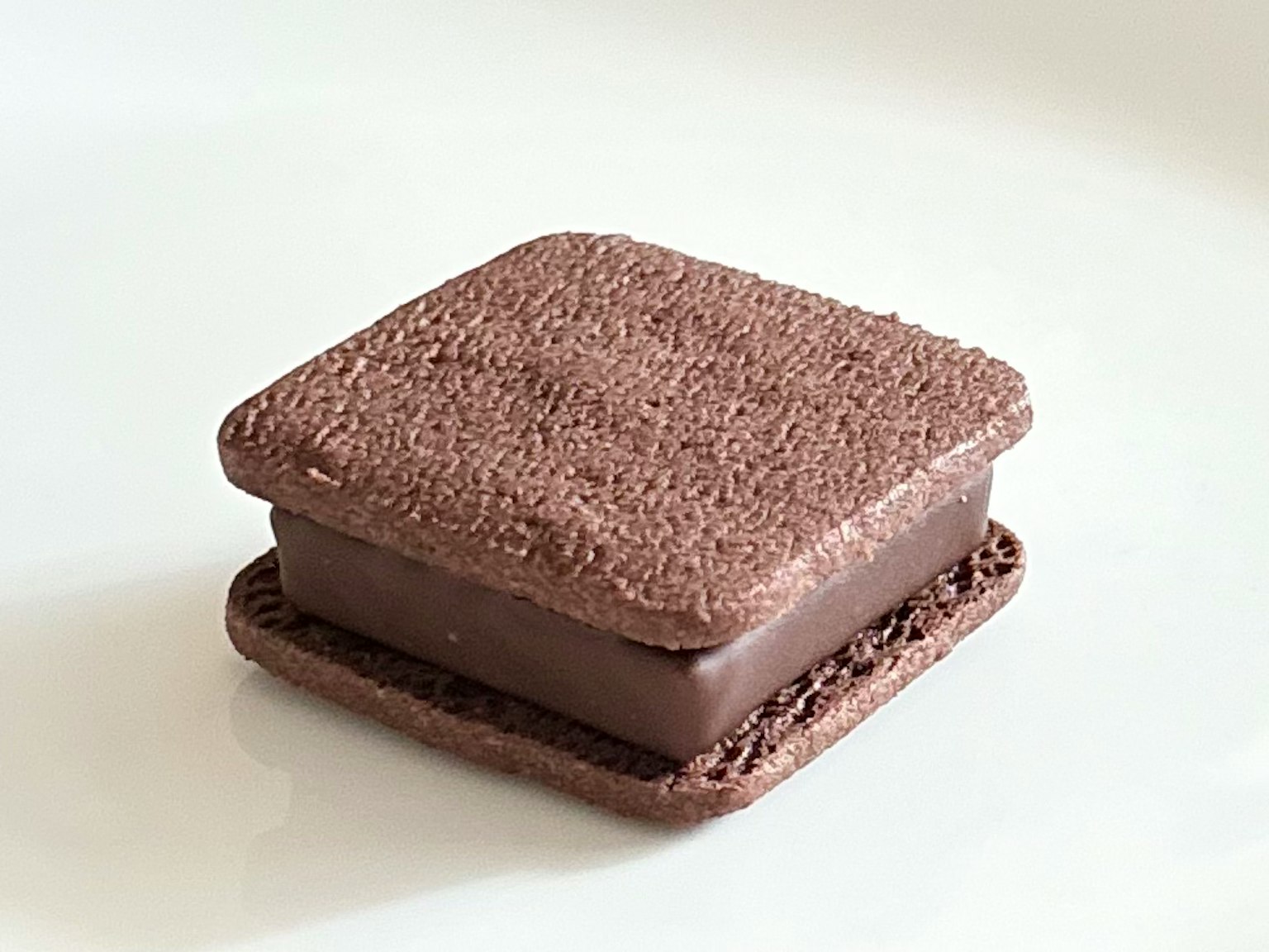 Galleta sándwich de chocolate con una capa superior e inferior de textura similar a un brownie