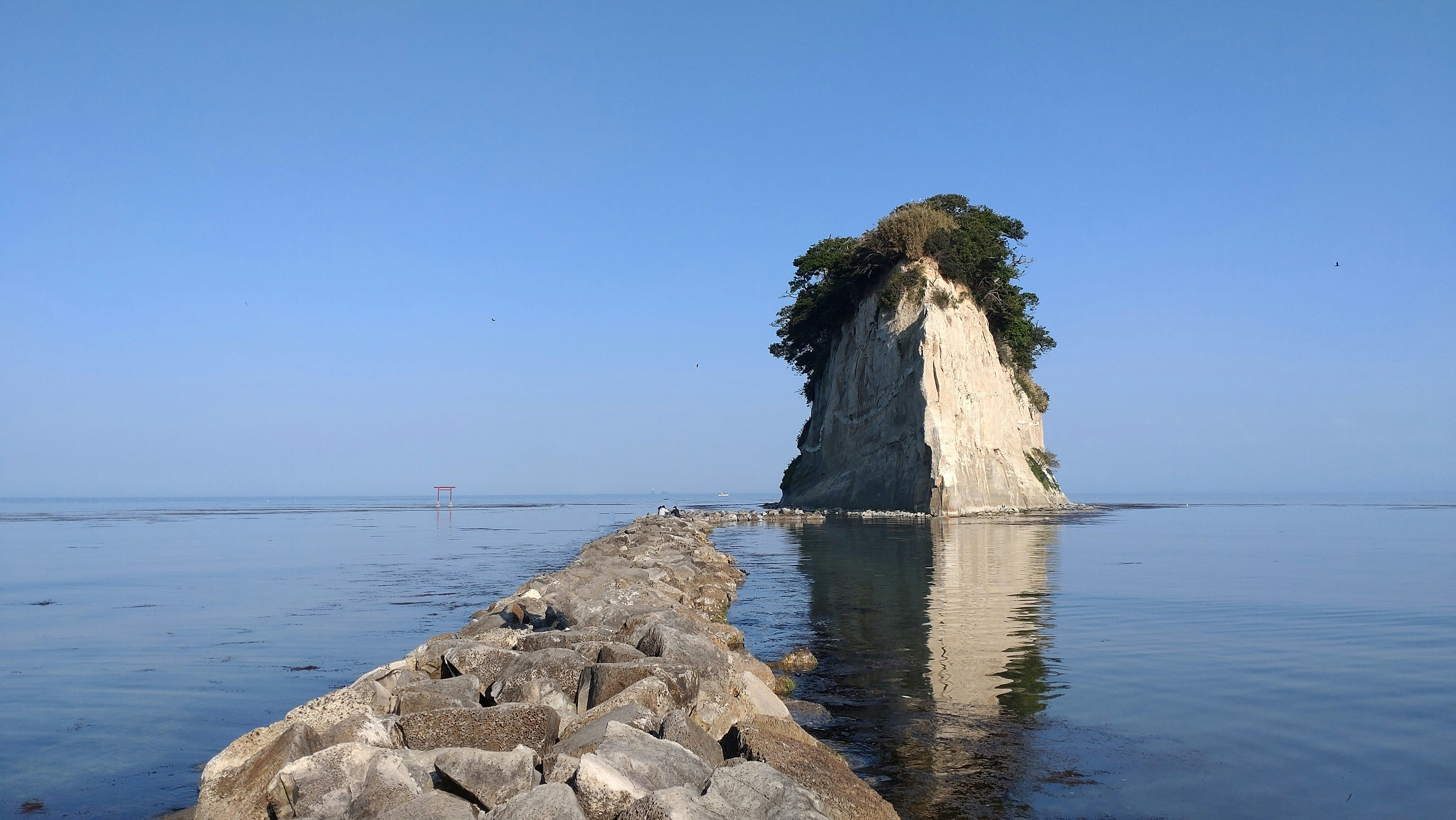 見附島の岩礁と海面に映る姿