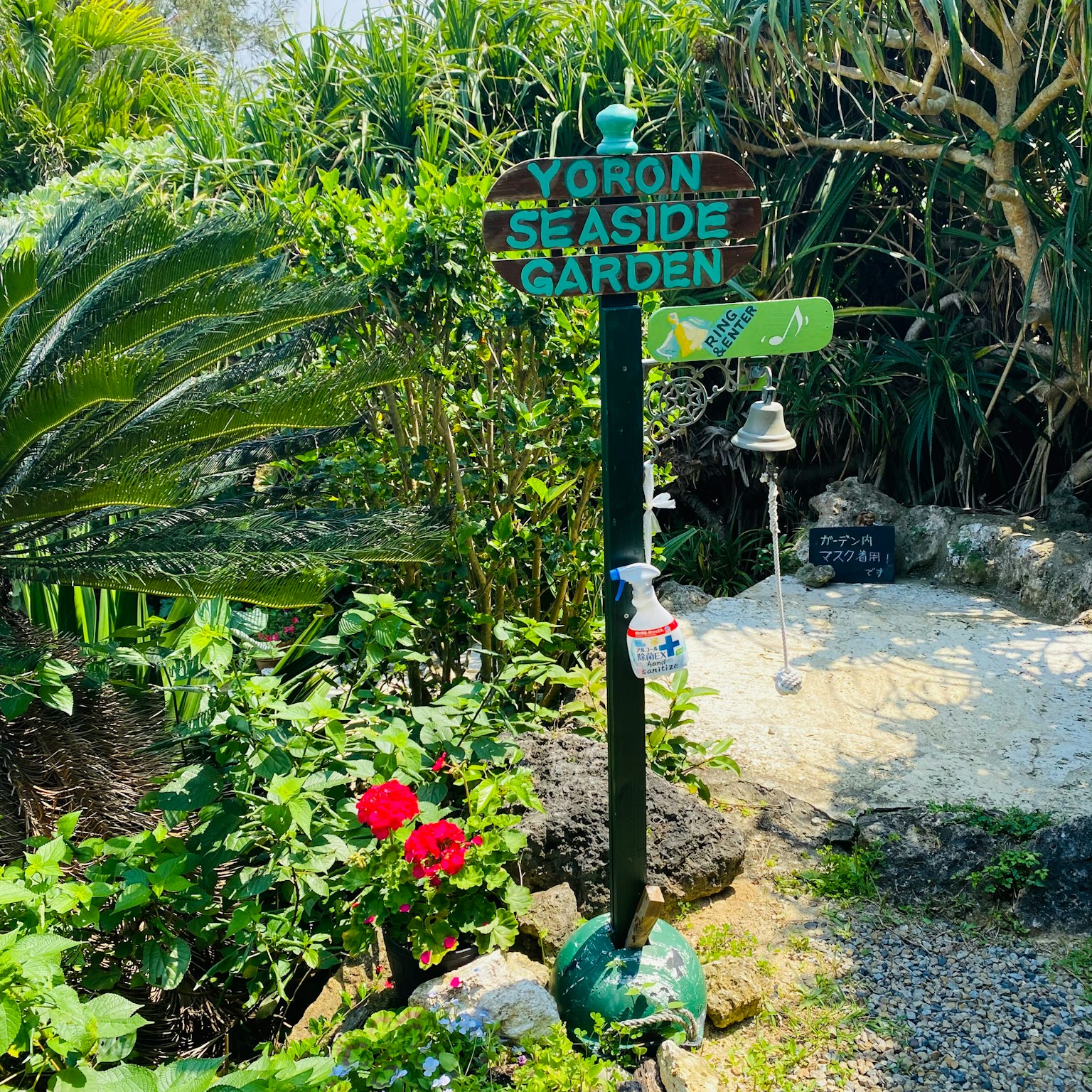 Cartel del Jardín Costero de Yoron en un entorno verde y exuberante
