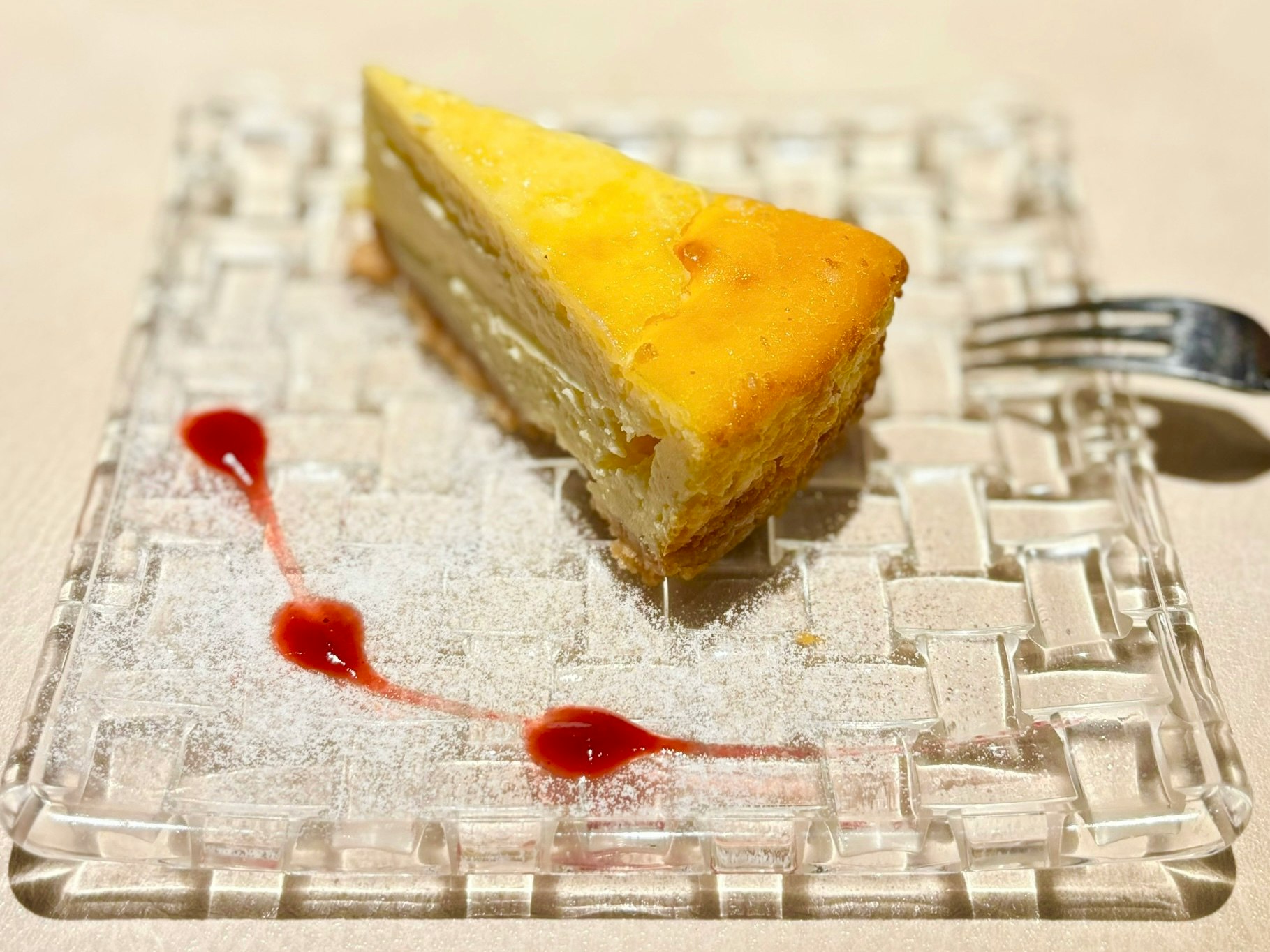sepotong cheesecake kuning di atas piring kaca
