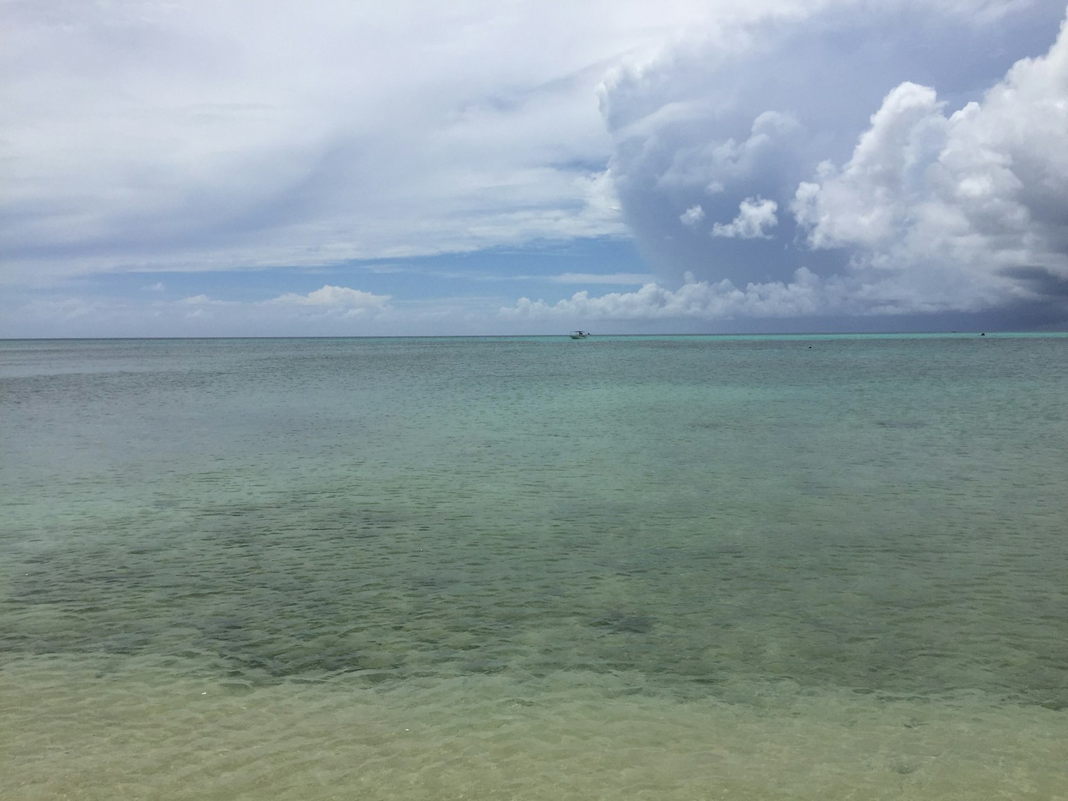 Vue sereine d'une mer calme sous un ciel nuageux