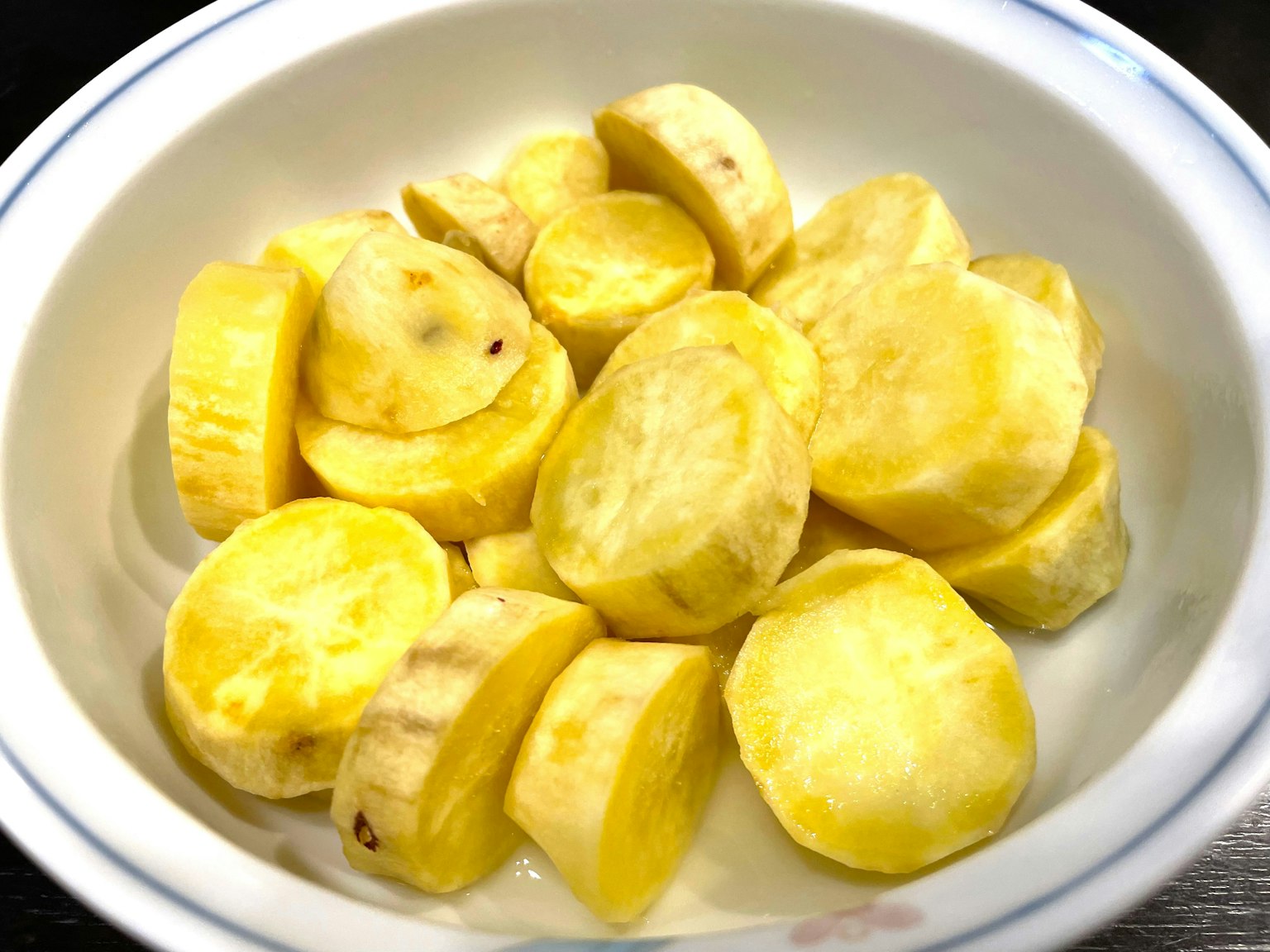 Patates douces jaunes tranchées disposées dans un bol blanc