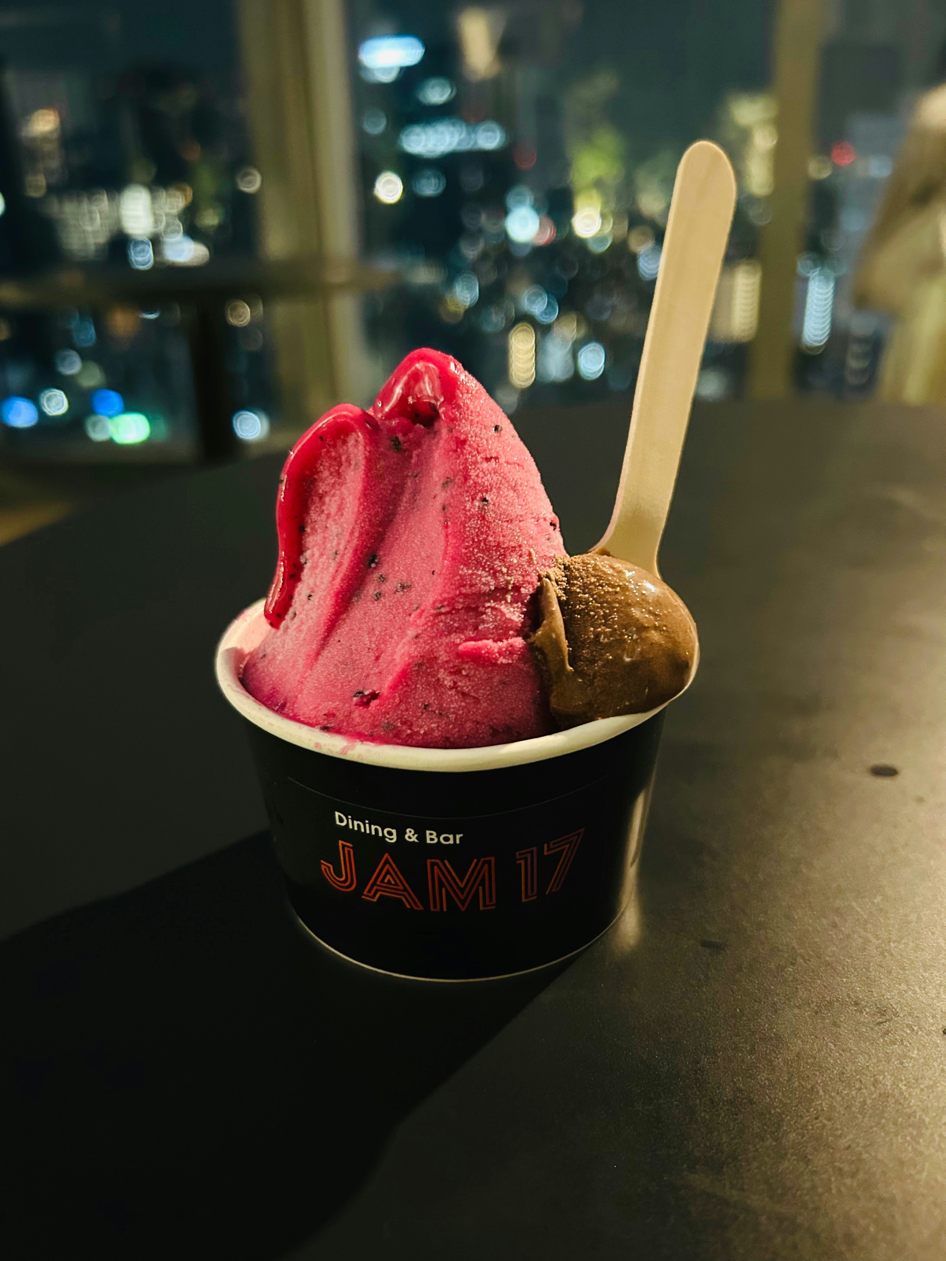 夜の街並みを背景にしたアイスクリームのカップ