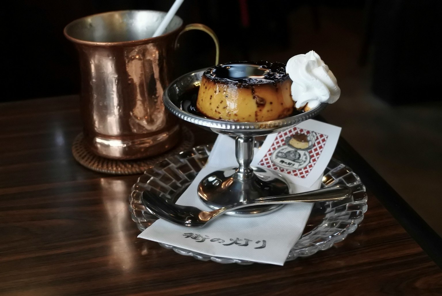 Presentación elegante del postre con taza de cobre y crema encima