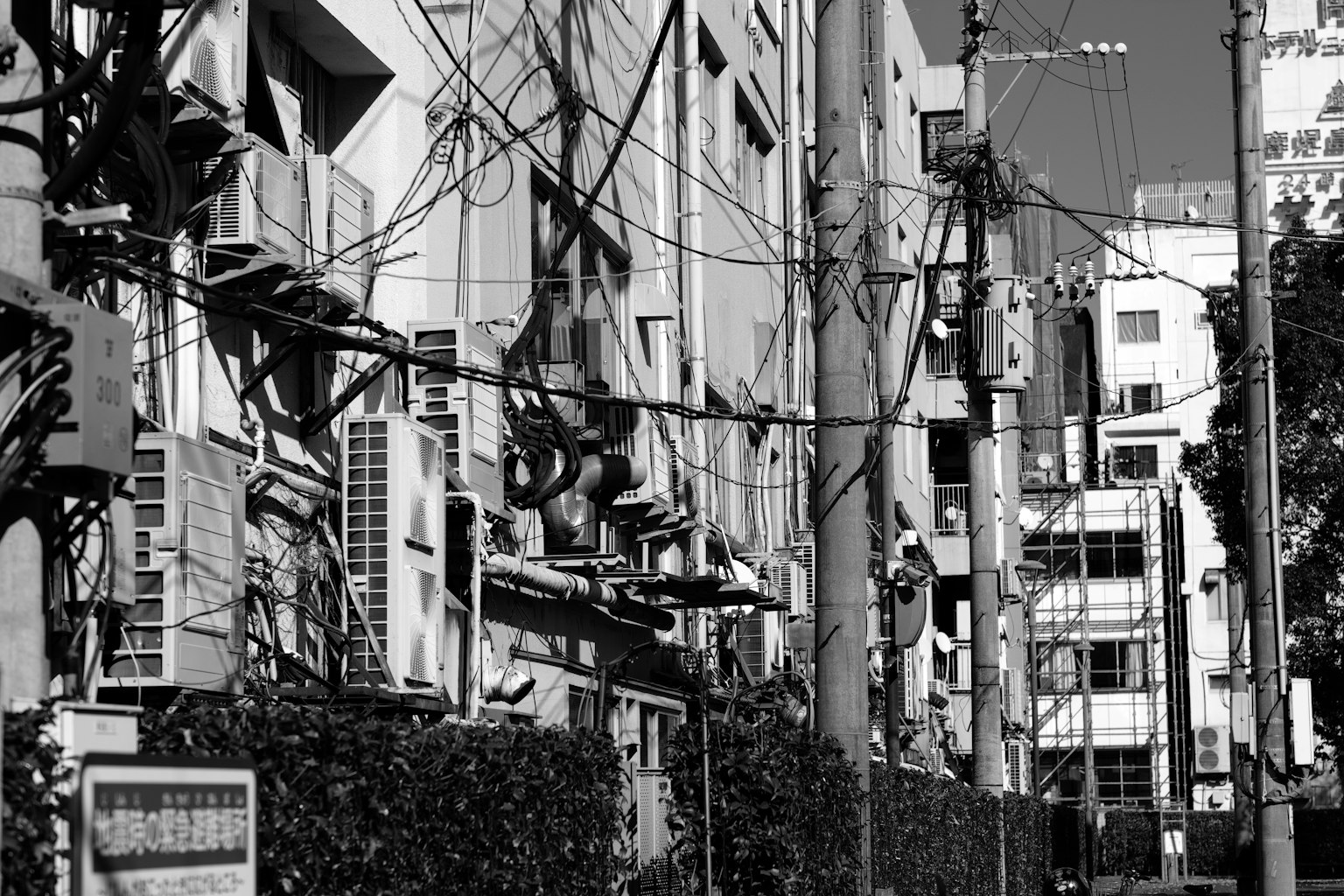 黑白城市景观，建筑物上有空调和电线