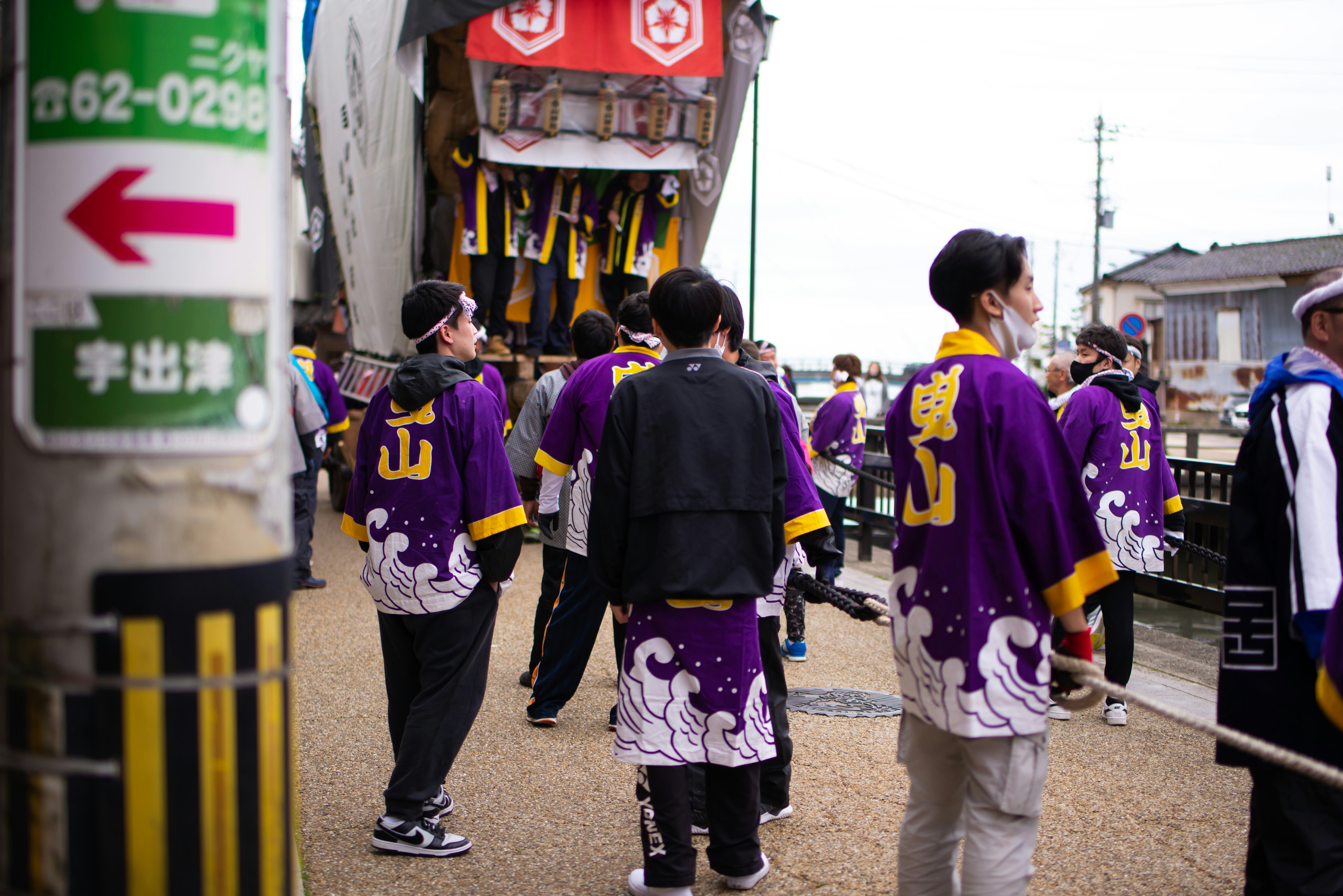 Street scene with people wearing happi coats for Utsu Hikiyama Festival