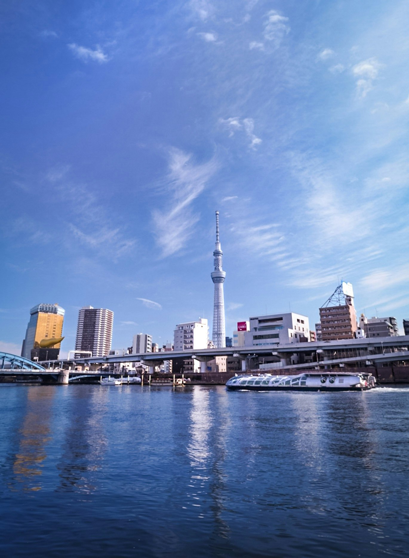 Vista della Tokyo Skytree sopra il fiume Sumida con un ponte