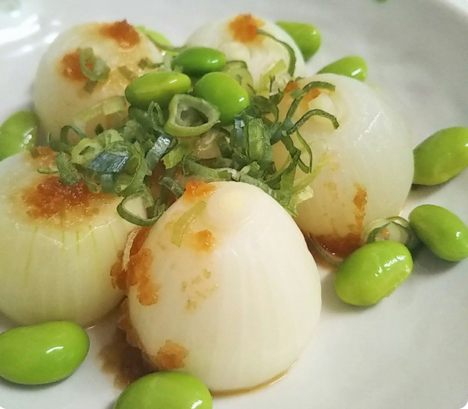 菜餚包含白色蘿蔔球，頂部是青蔥和毛豆