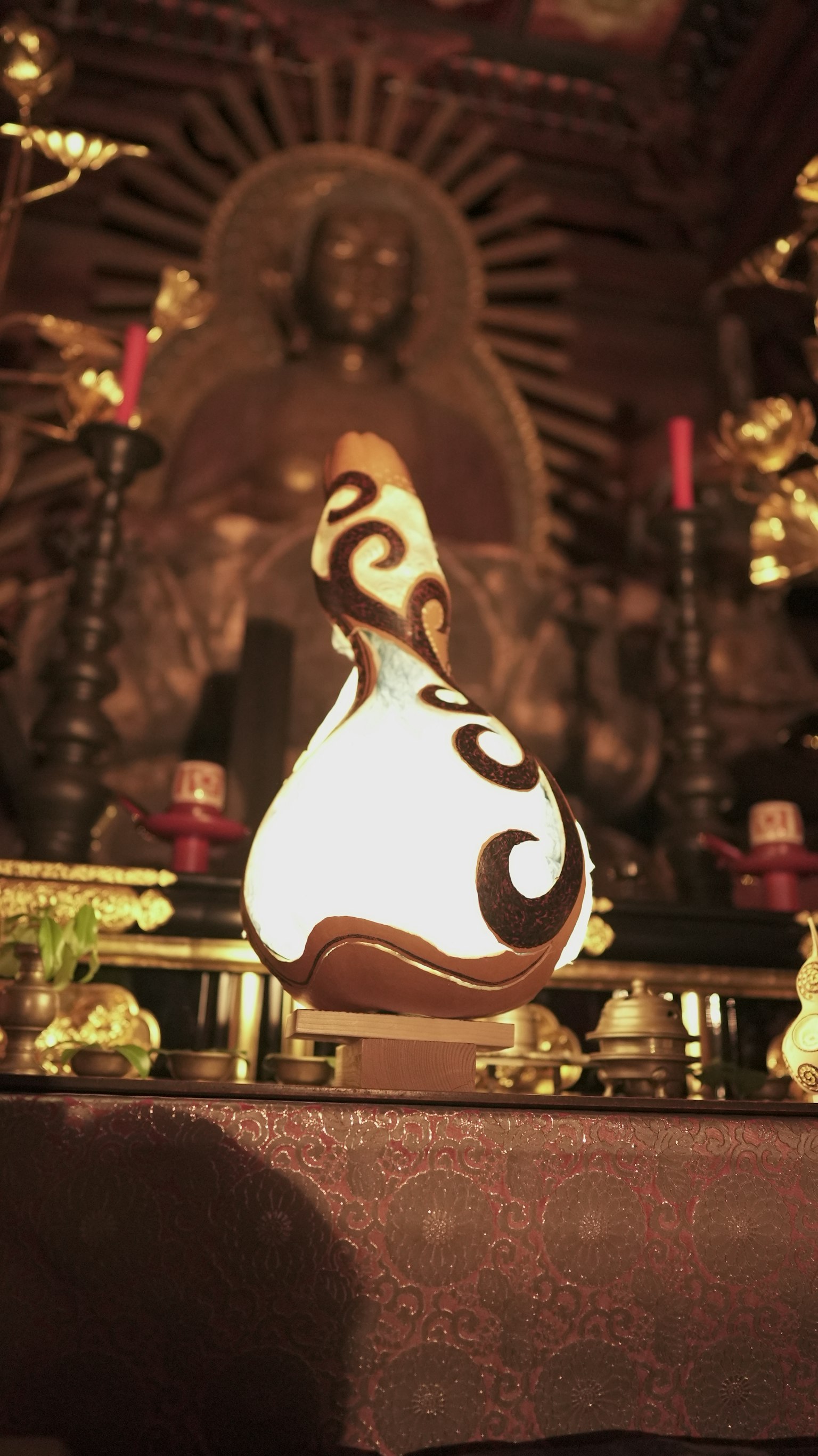 Decorative ceramic lamp placed in front of a Buddha statue