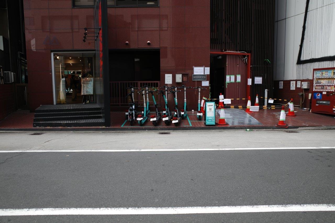 赤い自動販売機が並ぶ屋外の街角