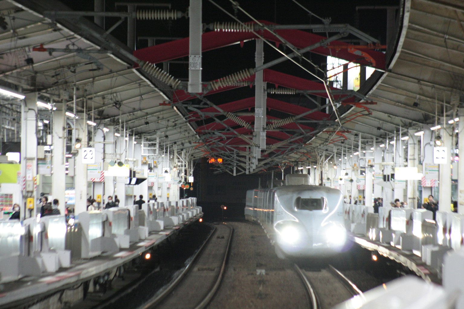 Kereta bercahaya di stasiun malam dengan peron kosong