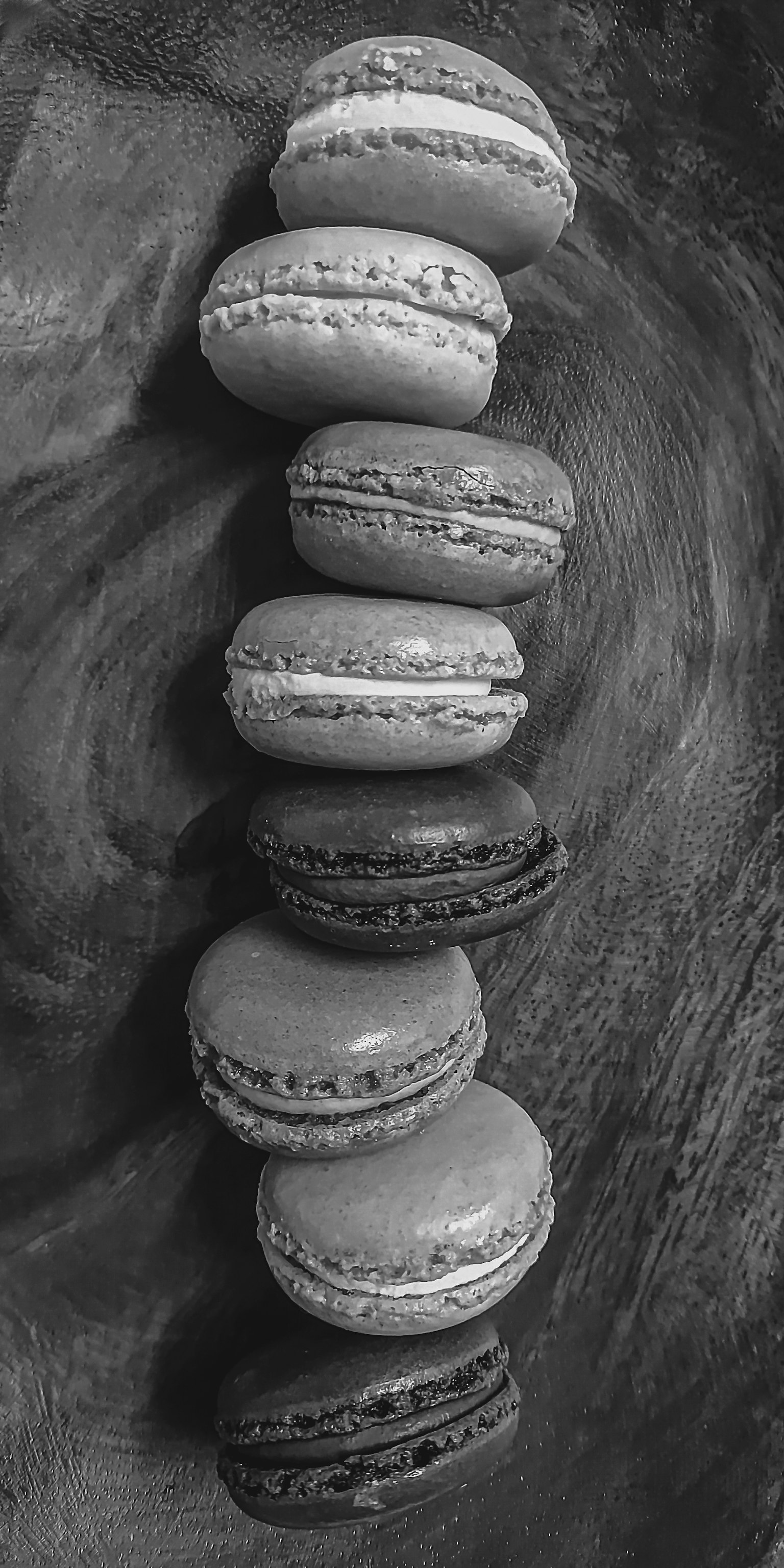 Una fila di macarons disposti su uno sfondo bianco e nero
