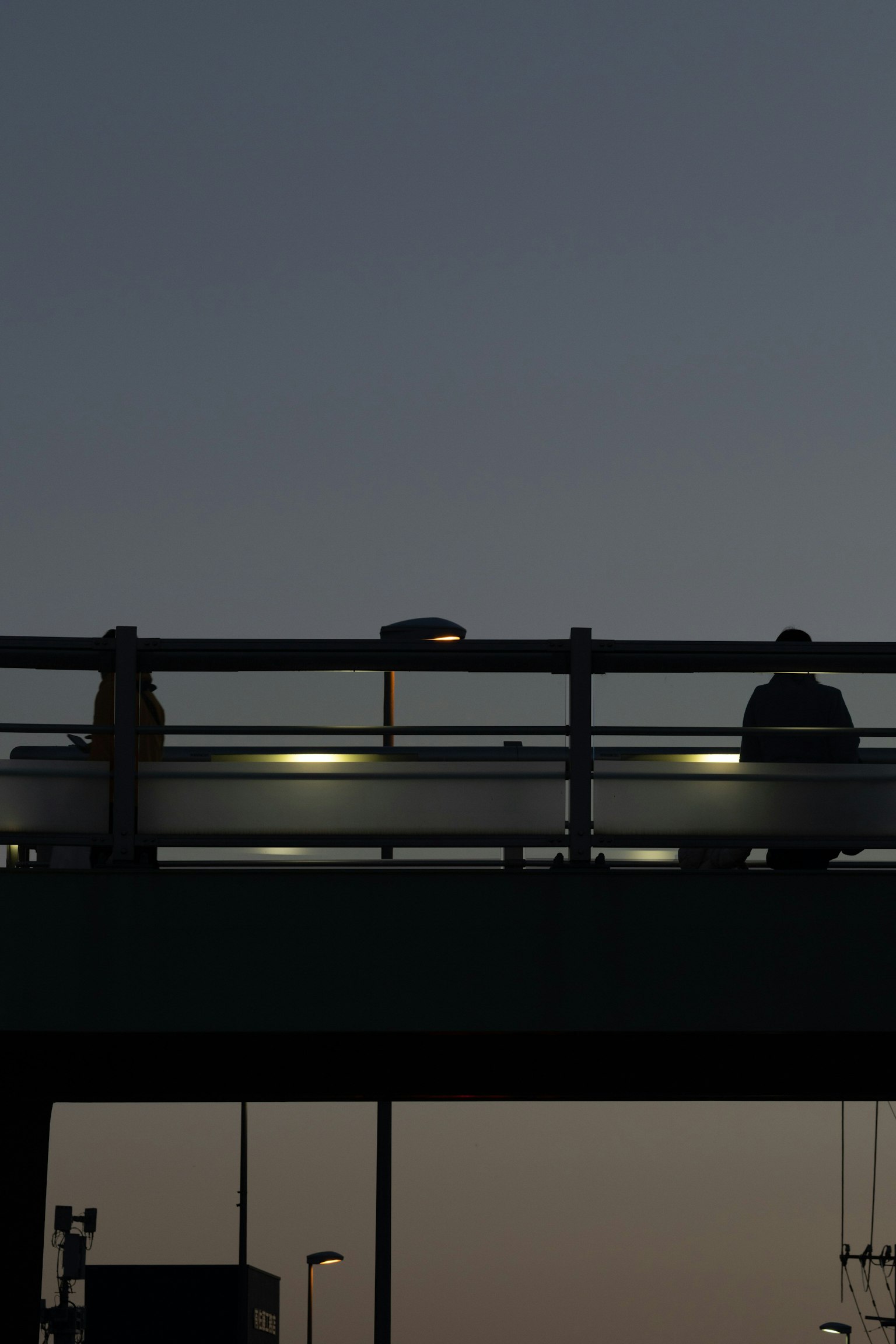 Silhouette d'un pont au crépuscule avec des piétons