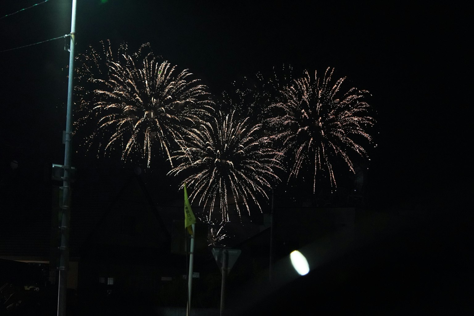 Tres fuegos artificiales vibrantes estallando en el cielo nocturno