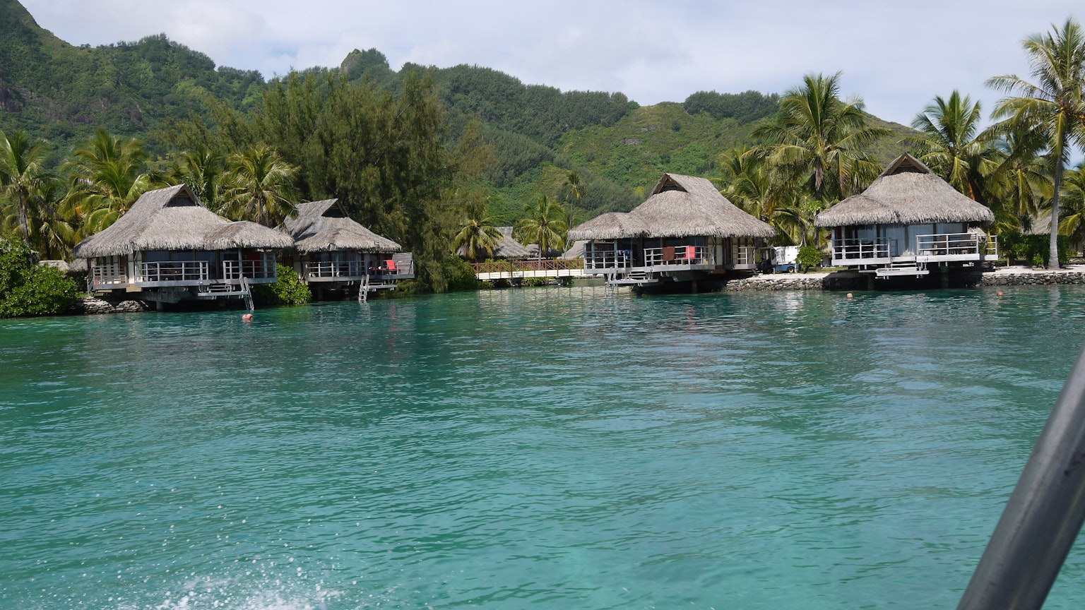 Escenario tropical con hermosos bungalós sobre el agua y montañas verdes