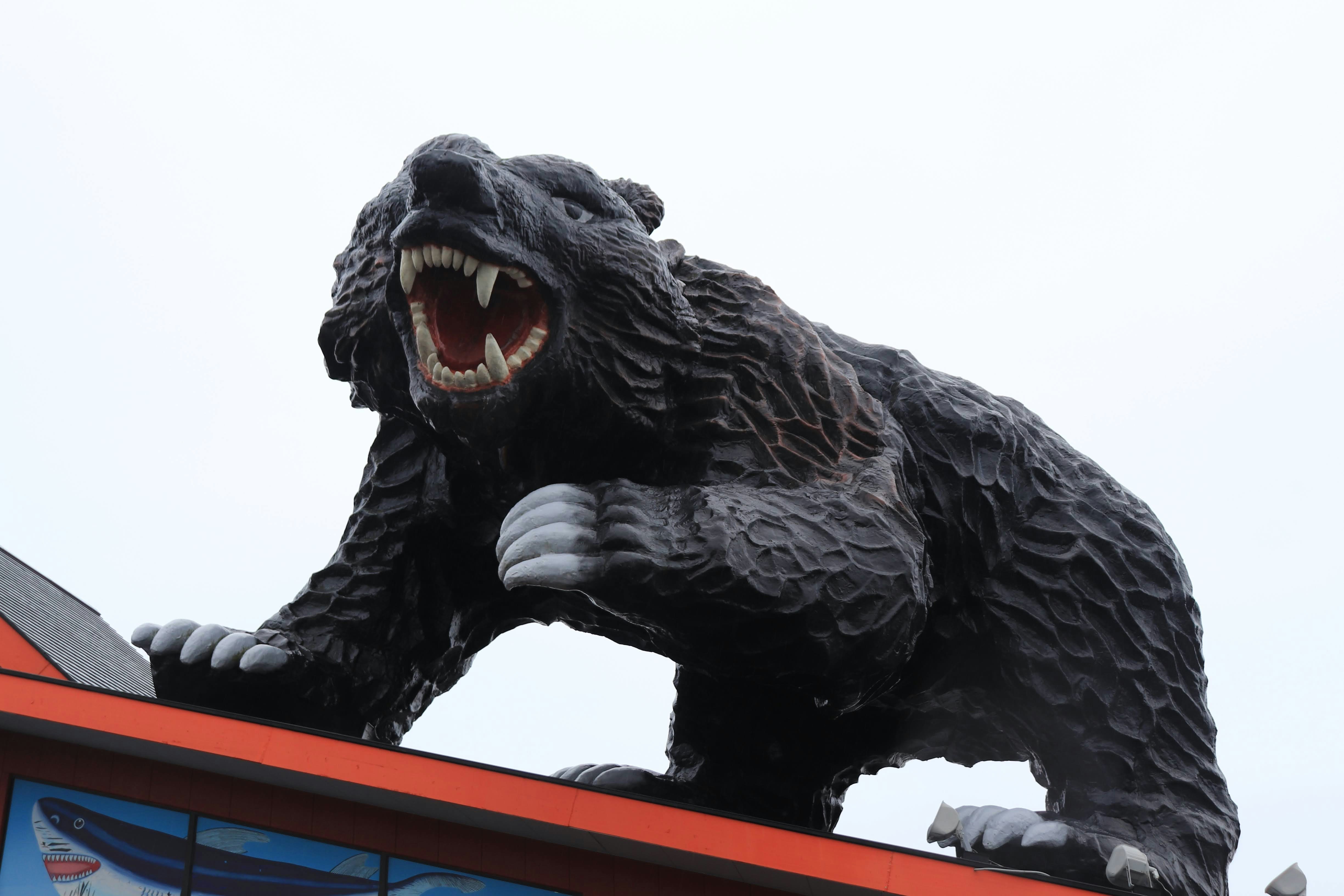 schwarze Monsterstatue auf dem Dach mit geöffnetem Maul