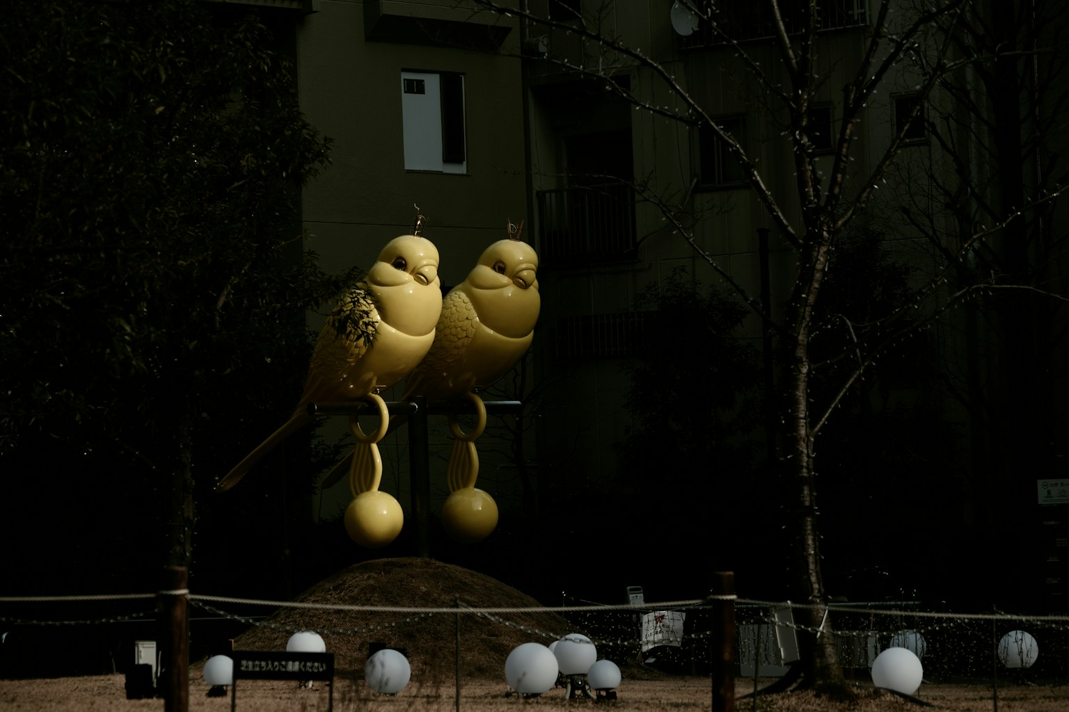 公園裡站著兩隻黃色鳥雕塑