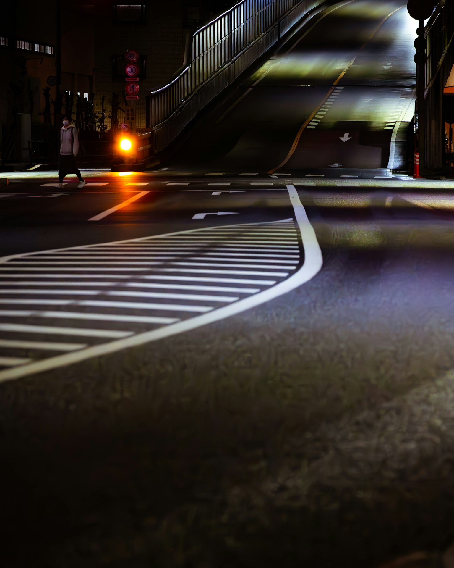 Route courbée dans une ville la nuit avec des lampadaires et des marquages routiers