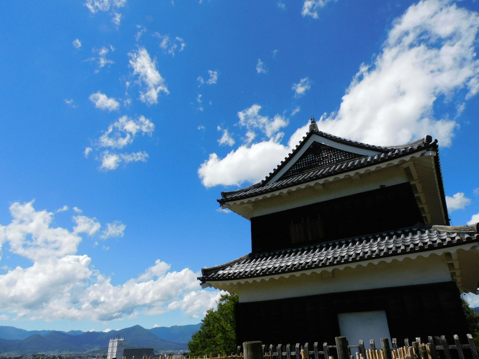 Structure de château japonais traditionnel sous un ciel bleu avec des nuages