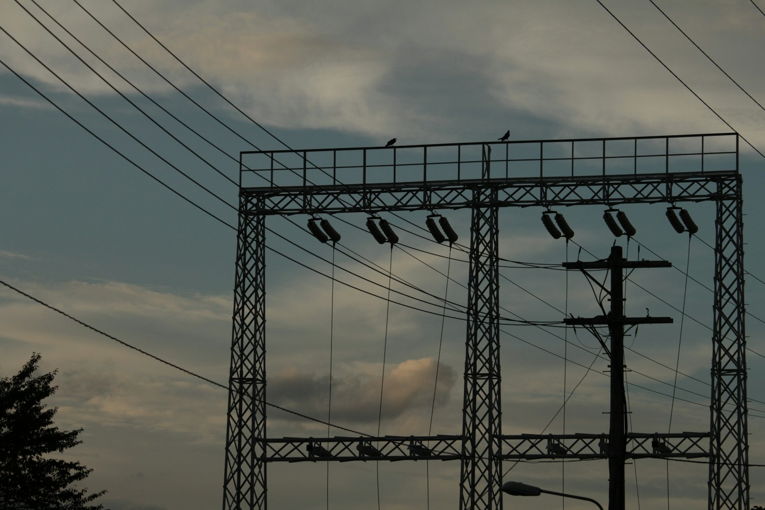 Silhouette des lignes électriques et des tours au crépuscule