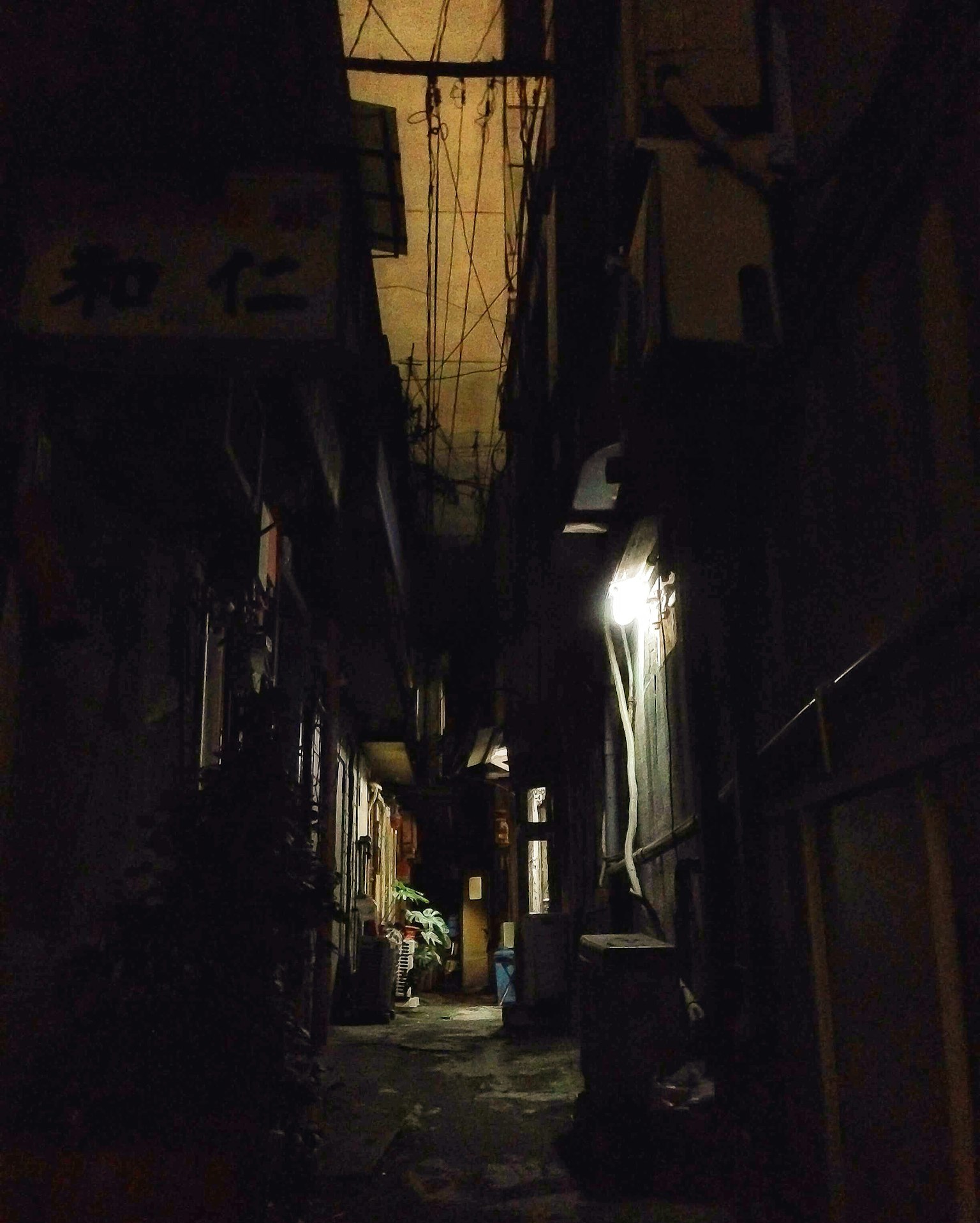 Callejón estrecho con iluminación tenue y sombras