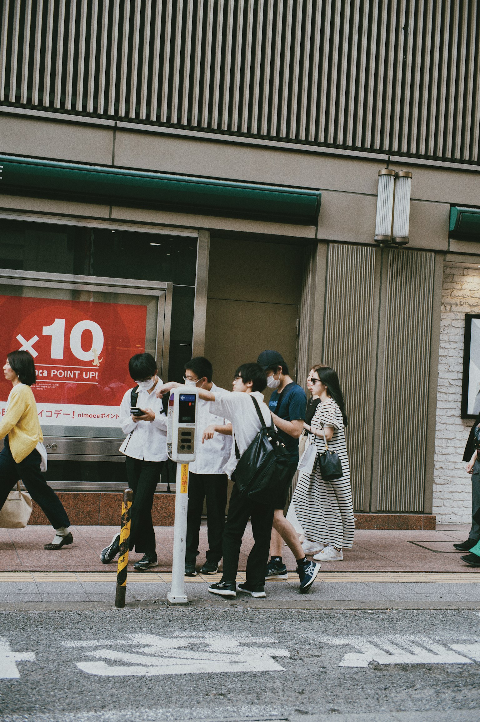 People walking on the street with a traffic signal visible
