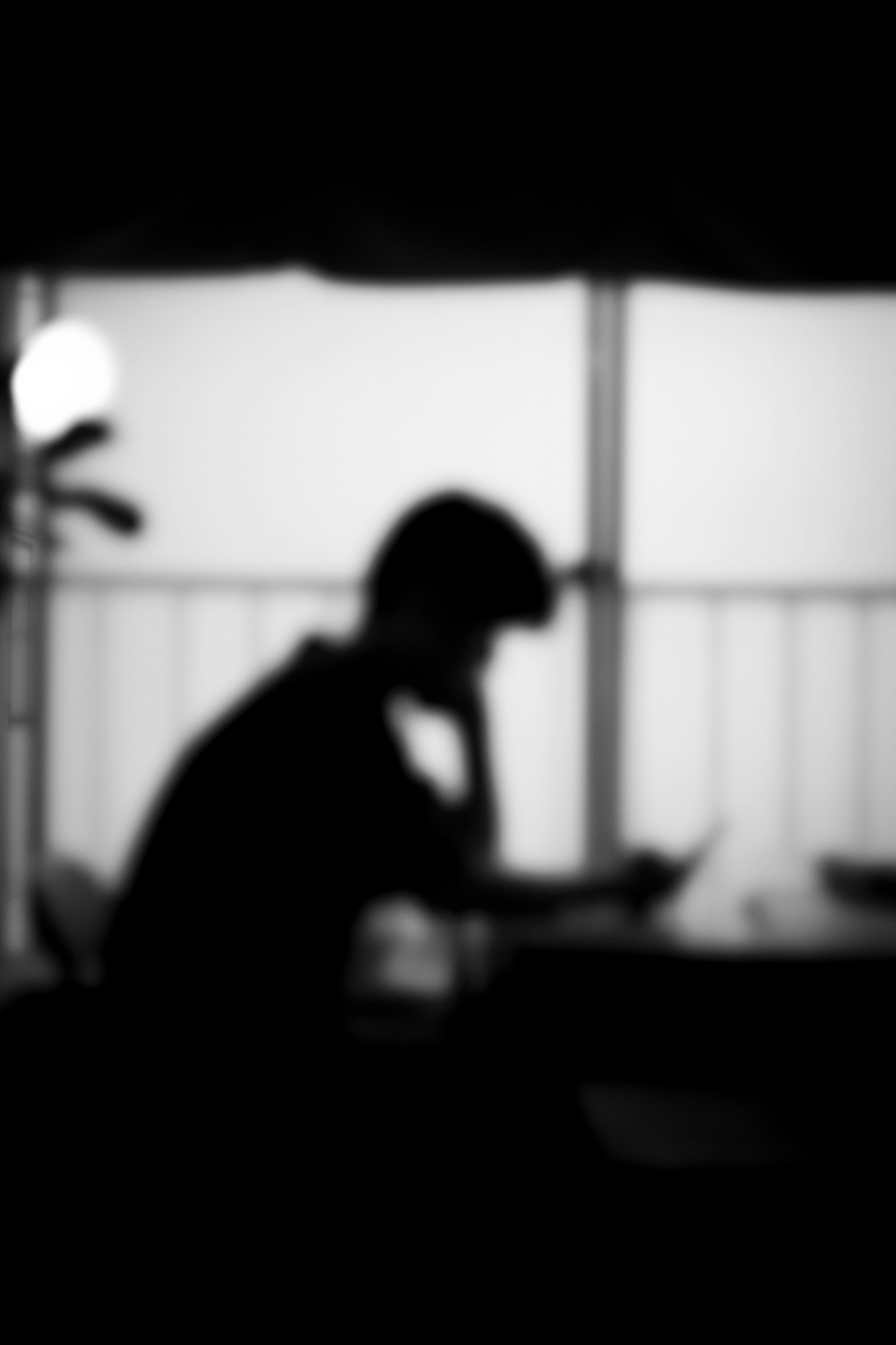 Silhouette di una persona immersa nei pensieri vicino a una finestra