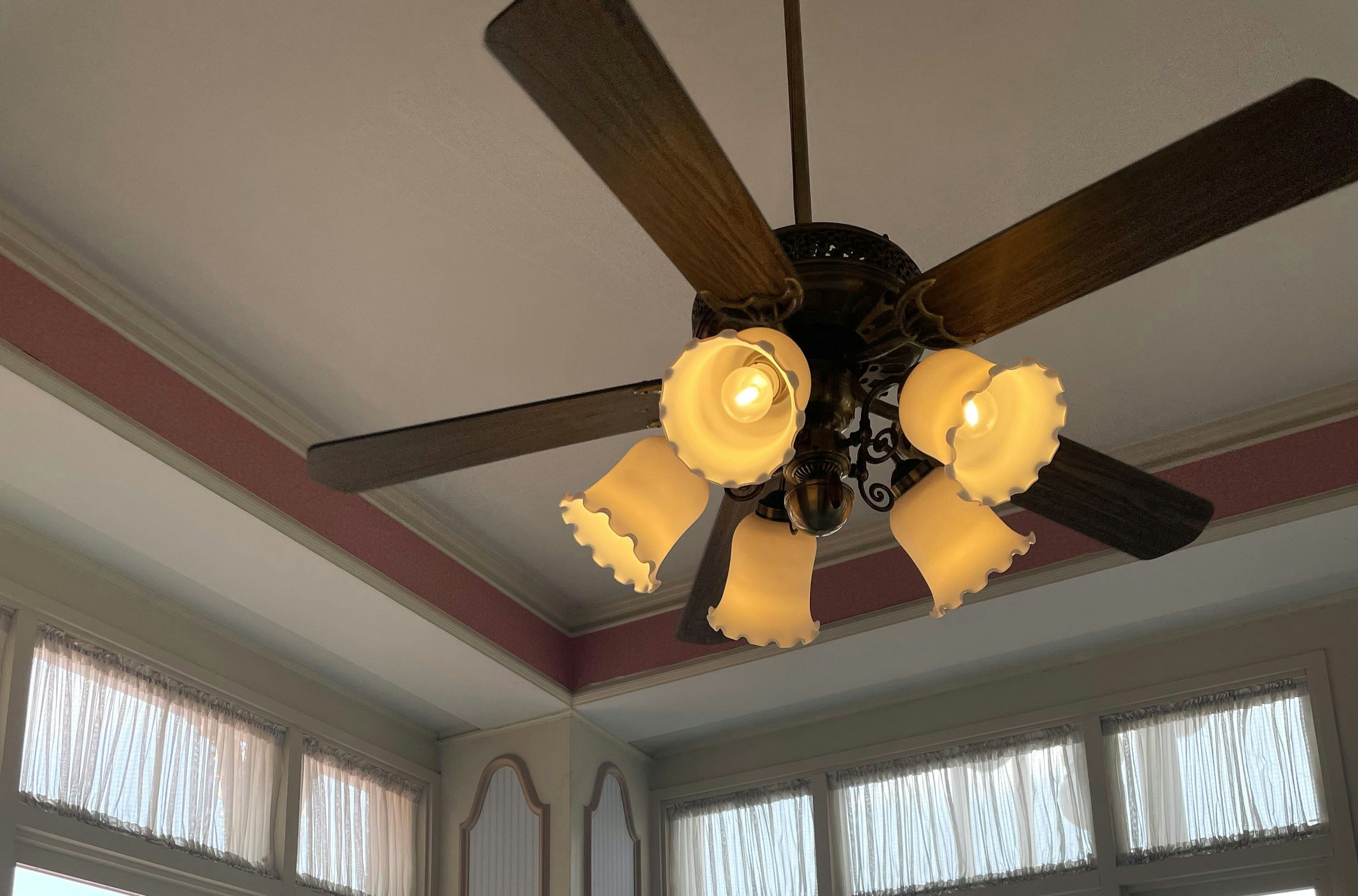 bright indoor room with a ceiling fan and chandelier-style light