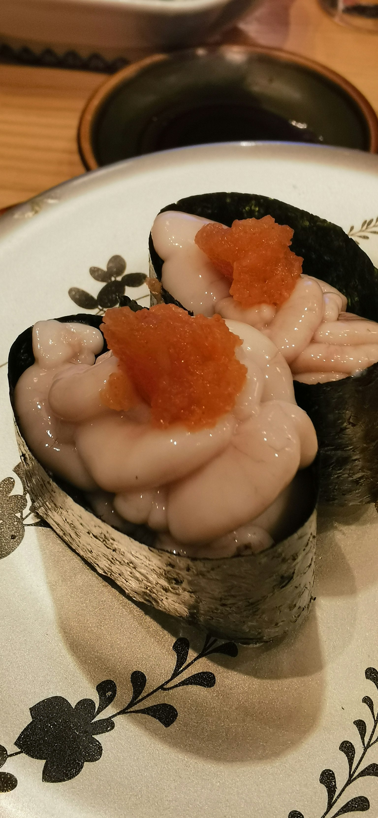 จานซูชิที่มีนิกิริอาหารทะเลและไข่ปลาเปลือกสีส้ม