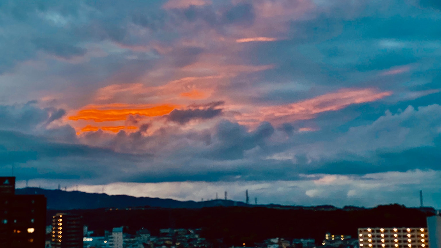 Silueta de montañas y nubes contra un cielo de atardecer colorido