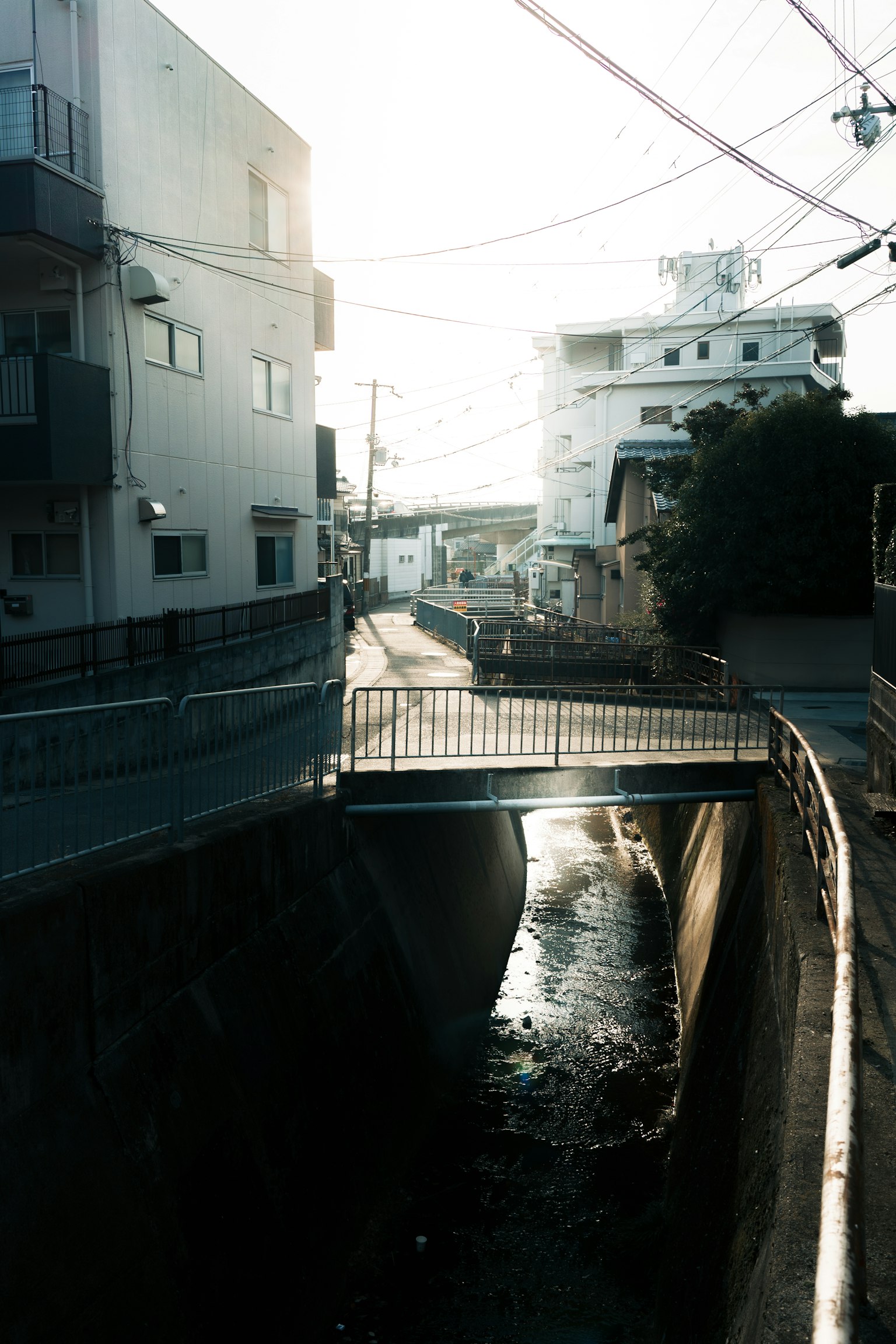 Curso de agua estrecho con un puente y edificios circundantes