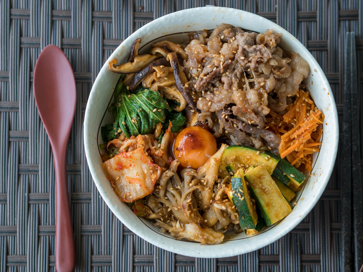 Un bol de bibimbap coréen avec des légumes assortis et des plats d'accompagnement