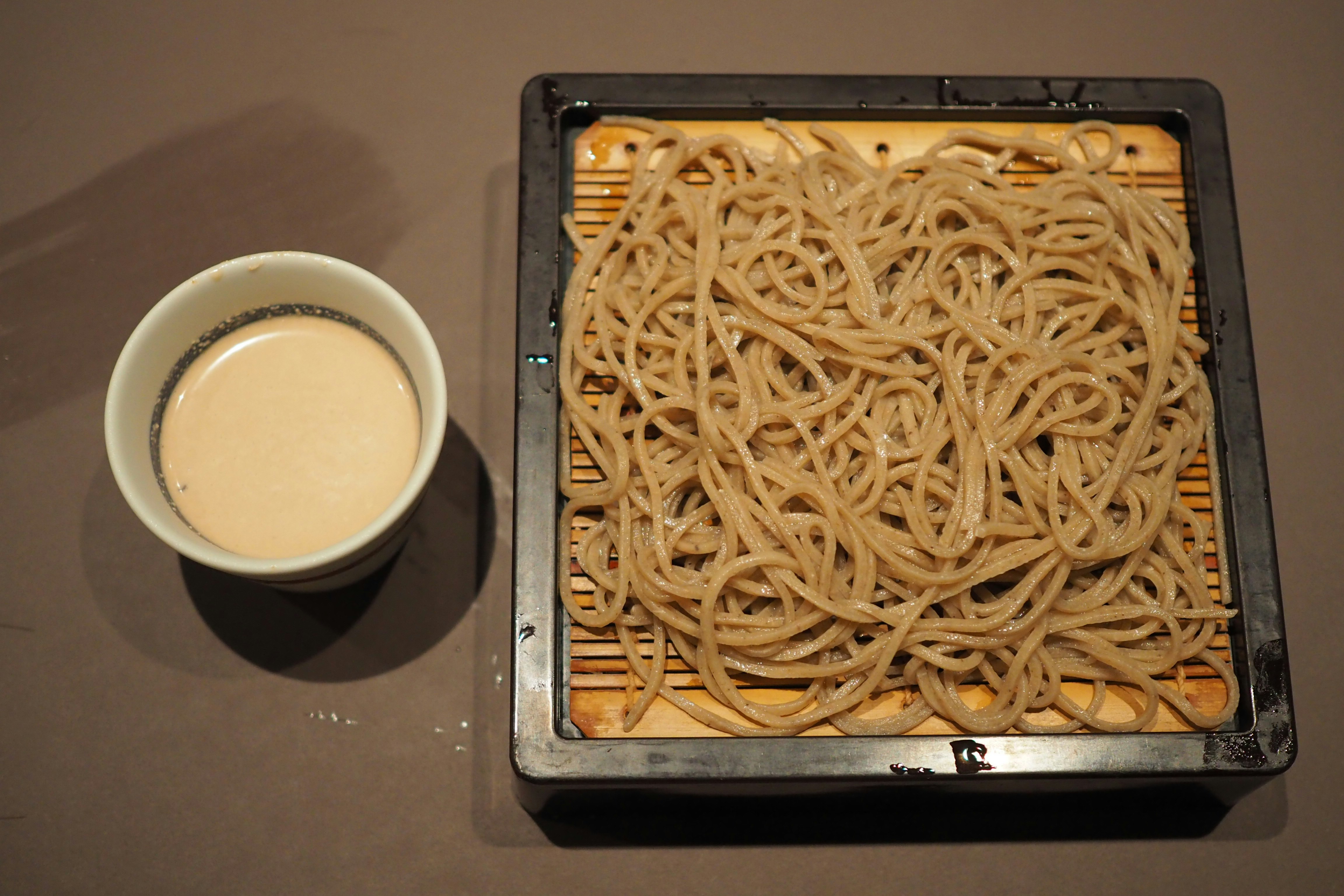 yakisoba di atas hot plate dengan secangkir minuman