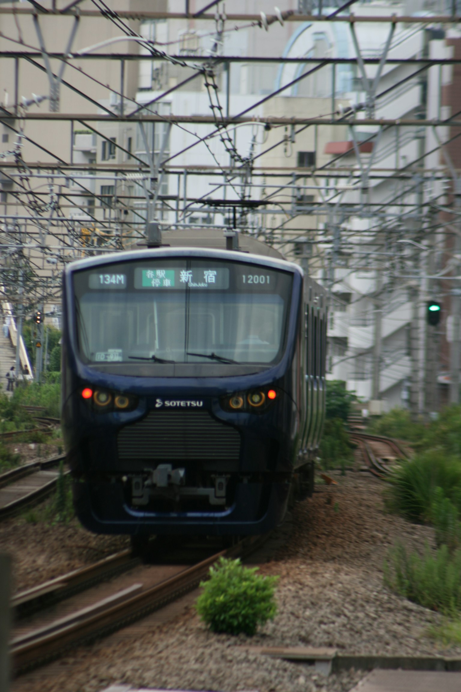 现代列车在城市铁路上行驶，轨道旁有绿草