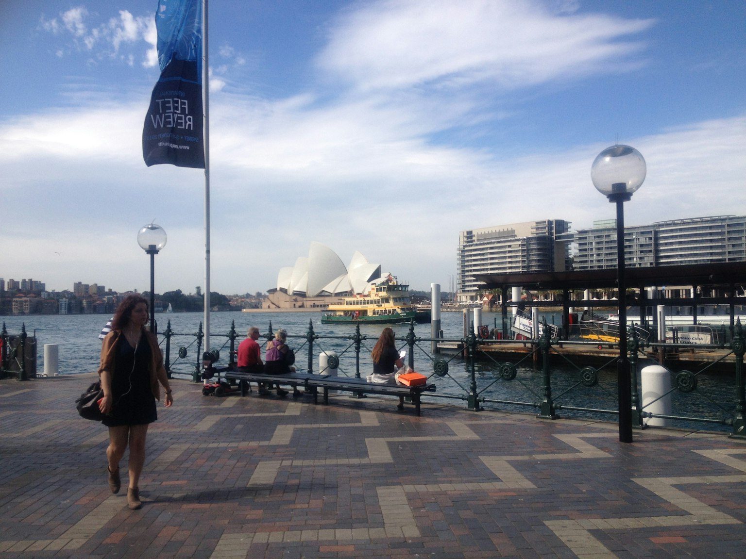 Pemandangan tepi laut dengan Sydney Opera House dan orang-orang yang berjalan