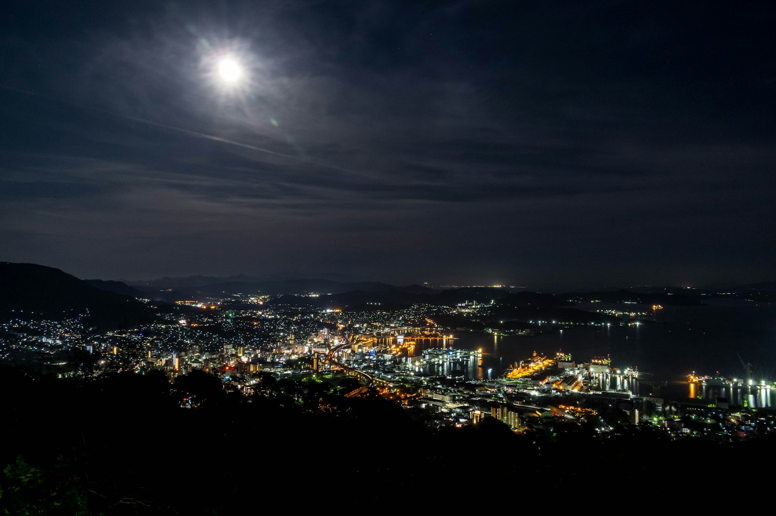 Pemandangan kota malam yang diterangi cahaya bulan