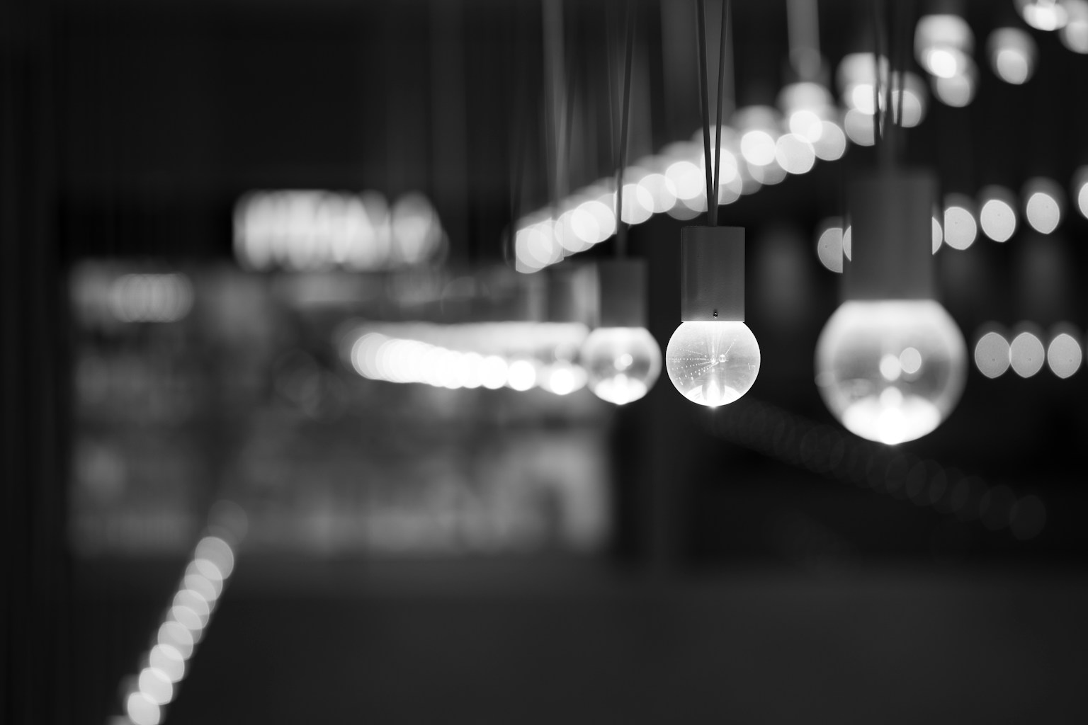 Hanging light bulbs in a black and white setting with blurred background