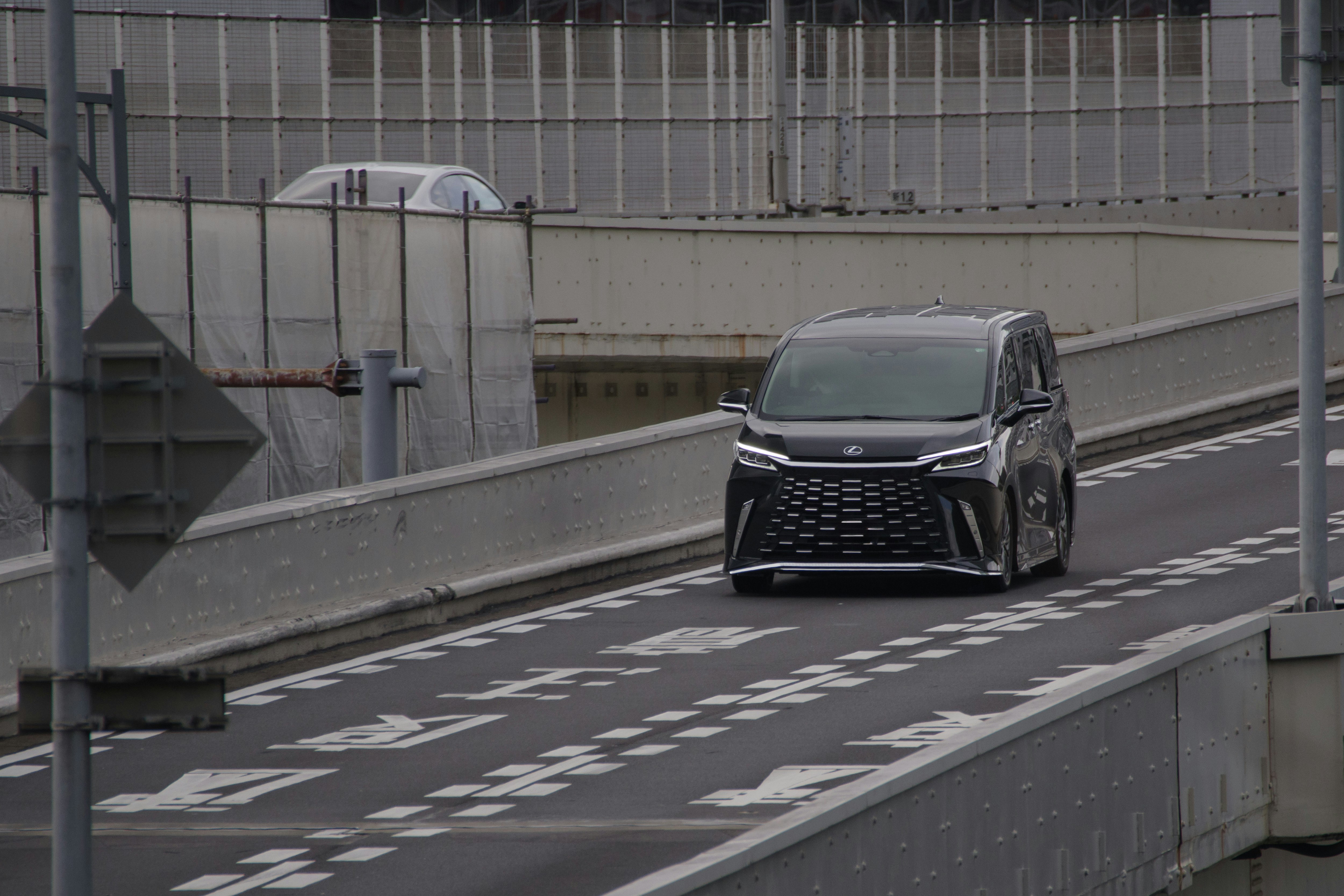 black Lexus car driving on an elevated road