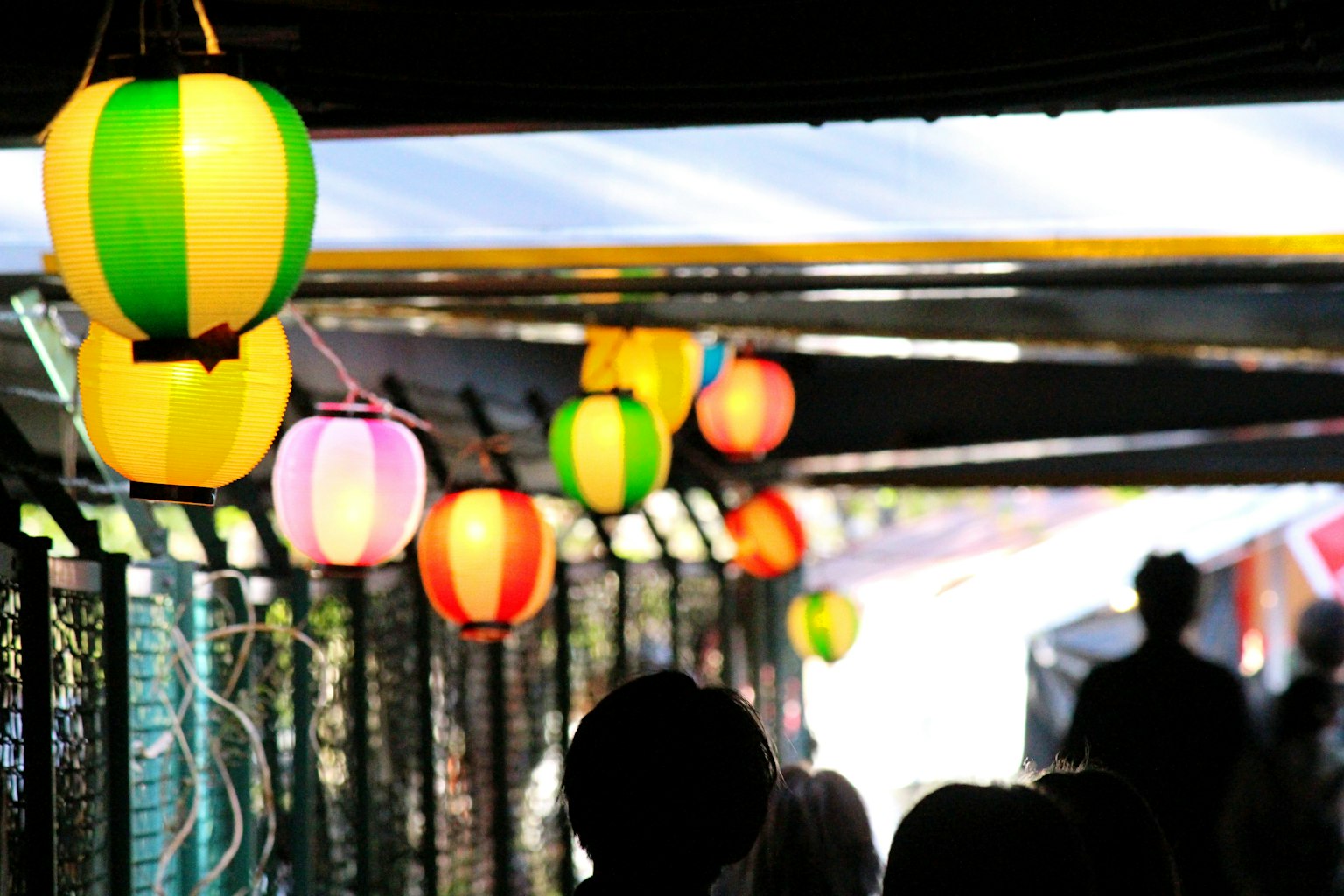 Faroles coloridos colgados en un pasillo de mercado