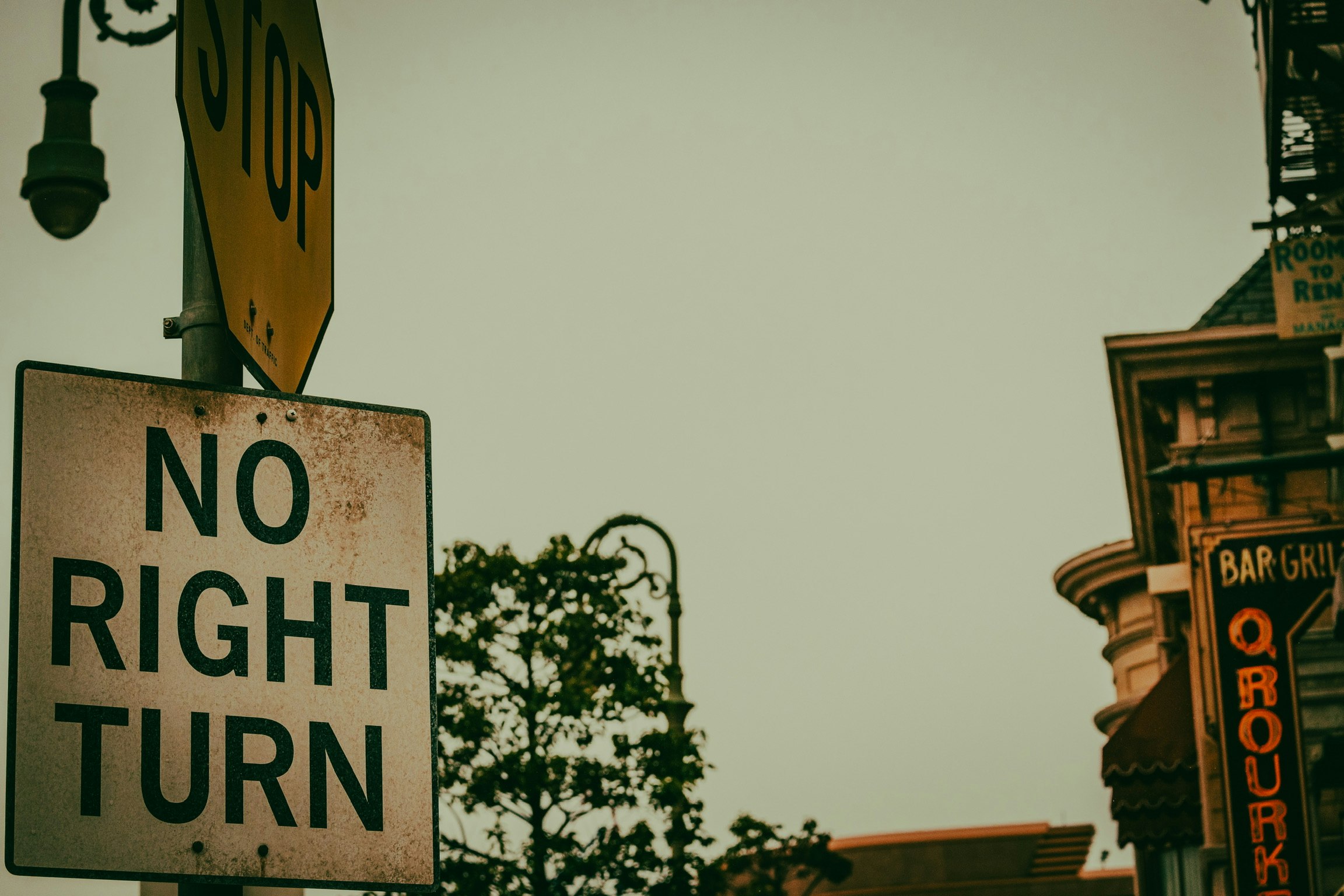 「NO RIGHT TURN」の標識と街角の建物