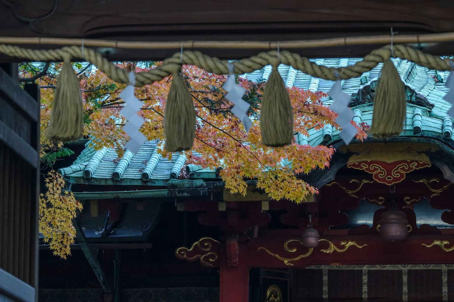 Vue d'un sanctuaire japonais avec des feuilles d'automne colorées sur le toit