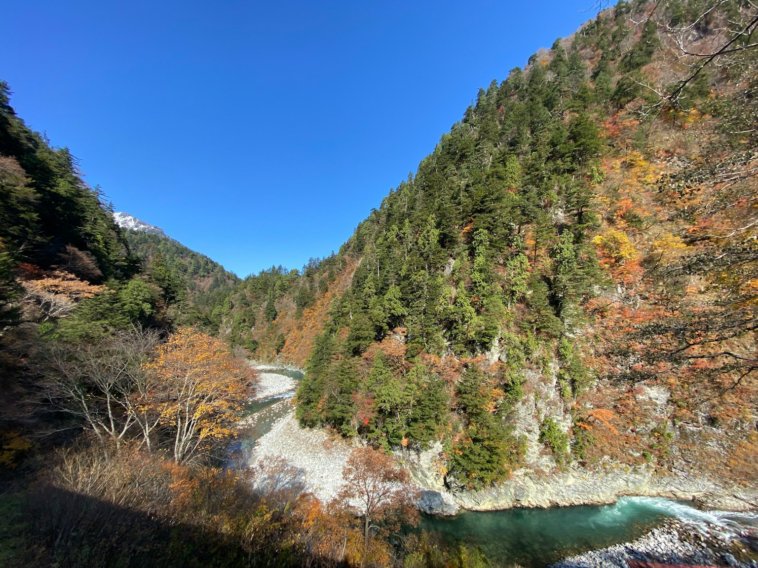 Vista escénica de montañas con un río serpenteante y follaje de otoño